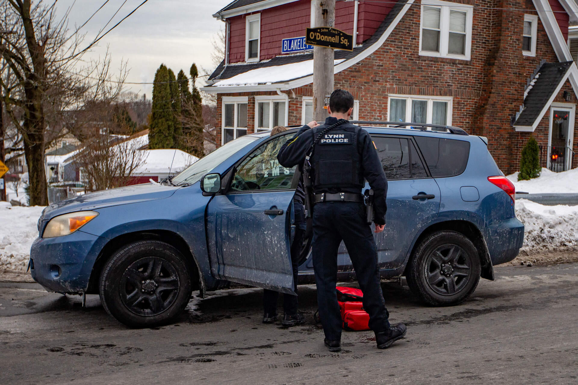 A Lynn police officer checks on a driver involved in a motor vehicle accident on Walnut Street in Lynn. (Jesse Costa/WBUR)