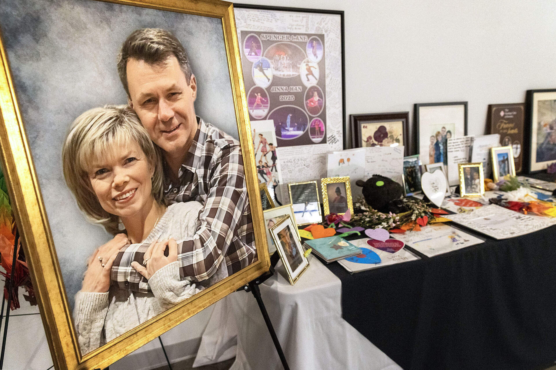 A painting of coaches Vadim Naumov and Evgenia Shishkova at a memorial for the members of the Skating Club of Boston who died in a January 2025 plane crash in Washington, D.C. (Robin Lubbock/WBUR)