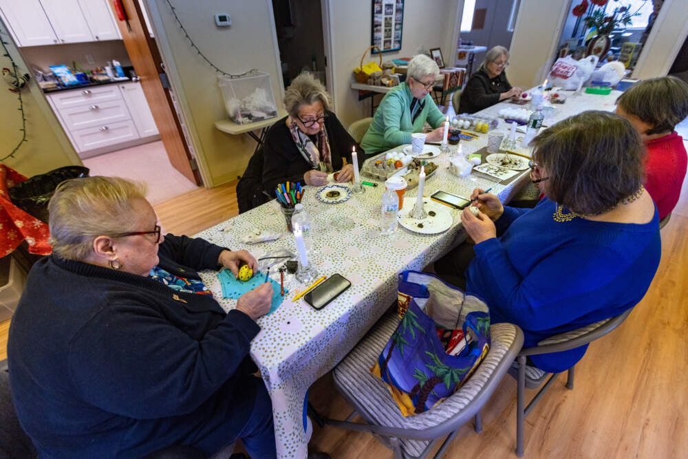 The Eggibabas sit at a table decorating eggs at the Ukrainian Youth Association office in Norwood. (Jesse Costa/WBUR)
