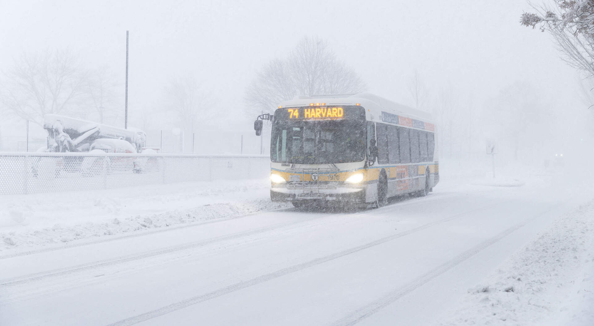 An MBTA bus drives through the snow on Concord Avenue in Cambridge Monday morning. (Robin Lubbock/WBUR)