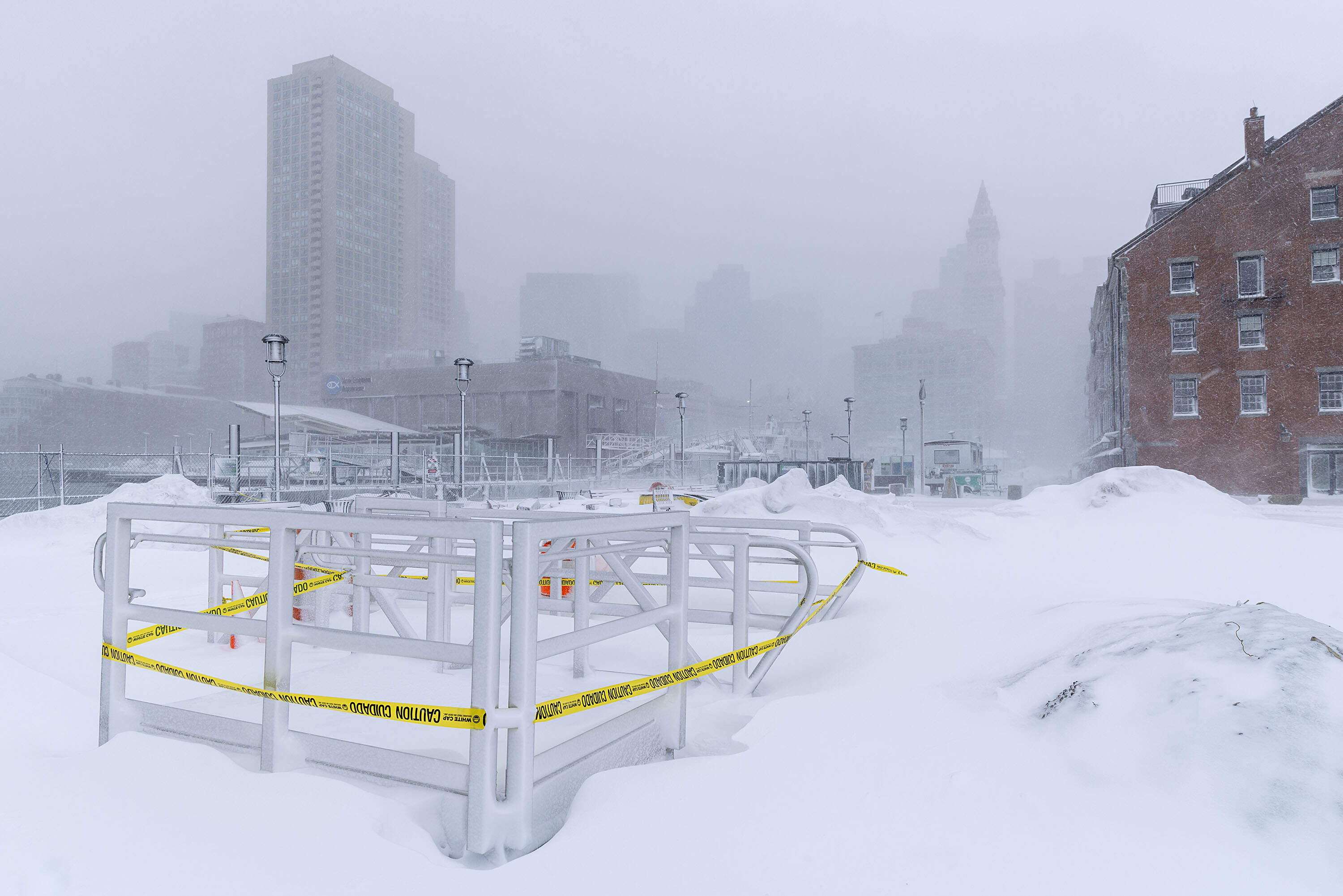From Long Wharf, Boston lies partially hidden by falling snow, as a nor’easter dumps snow on the city. (Robin Lubbock/WBUR)
