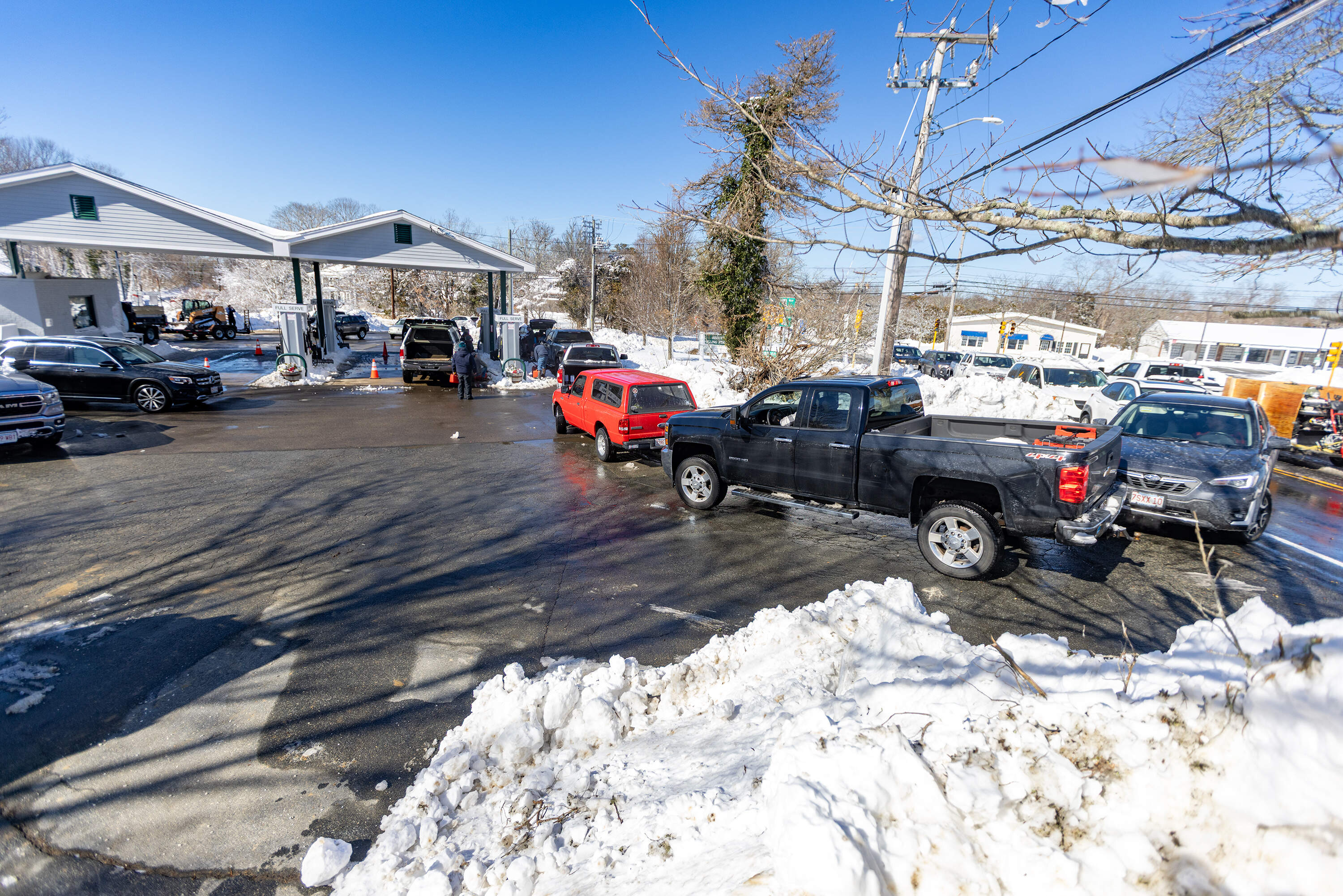 A long line for gas at the Sesuit Filling Station in Dennis. Only two pumps were operating because the station was running on generator power Tuesday. (Jesse Costa/WBUR)
