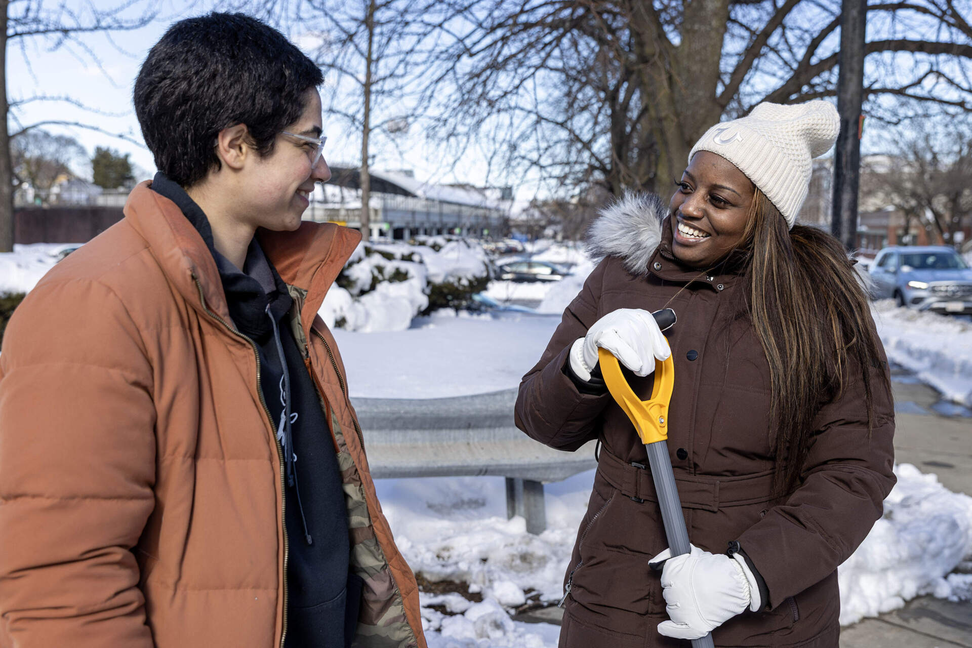Cecily Graham, Dept. Director for the Boston Mayor's Office of Neighborhood Services, holds her shovel as she talks with one of the volunteers clearing crosswalks near Forest Hills MBTA station. (Robin Lubbock/WBUR)