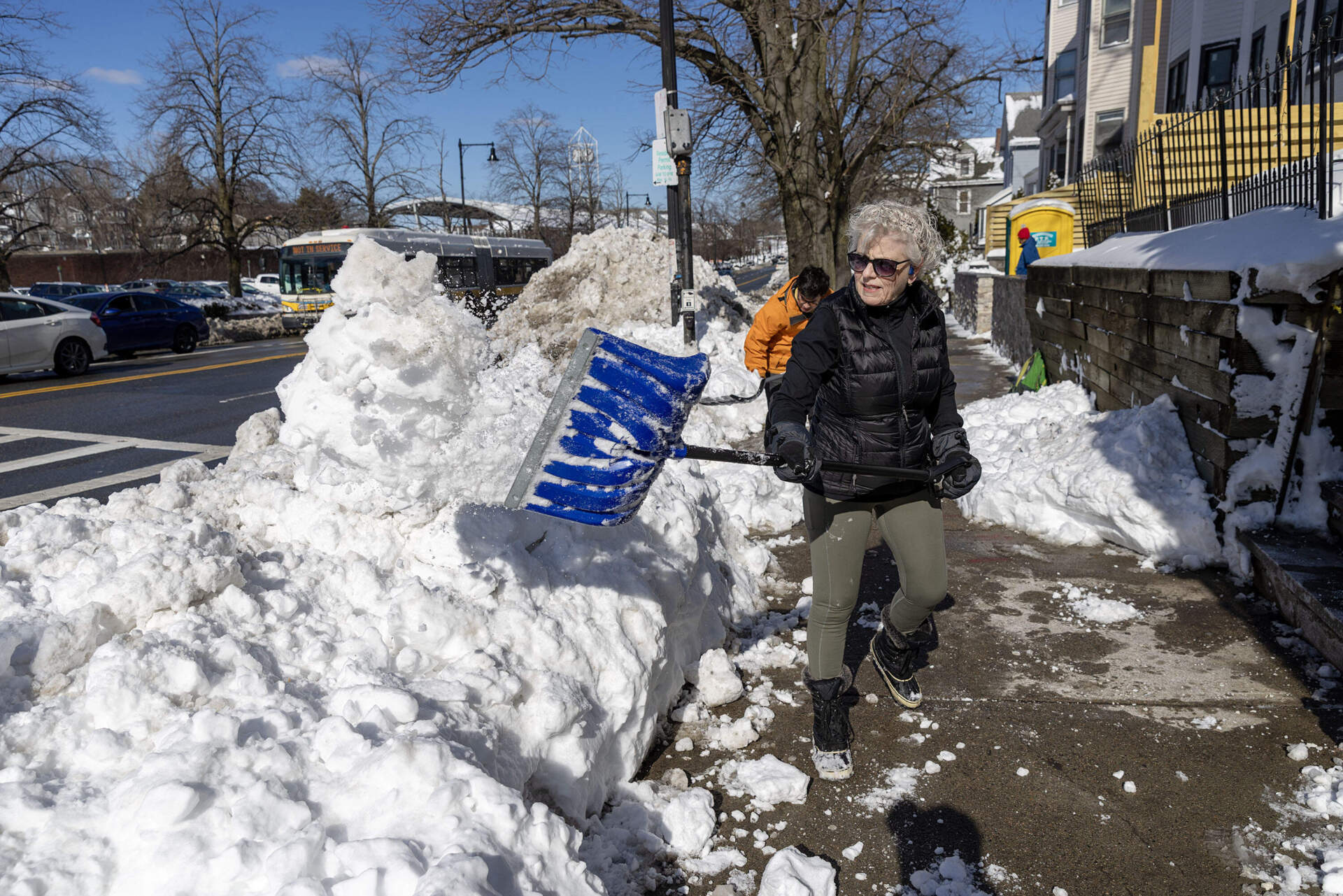 Volunteer Meg O'Brien works with a crew the Boston Mayor's Office of Neighborhood Services brought together to clear crosswalks in Jamaica Plain. (Robin Lubbock/WBUR)