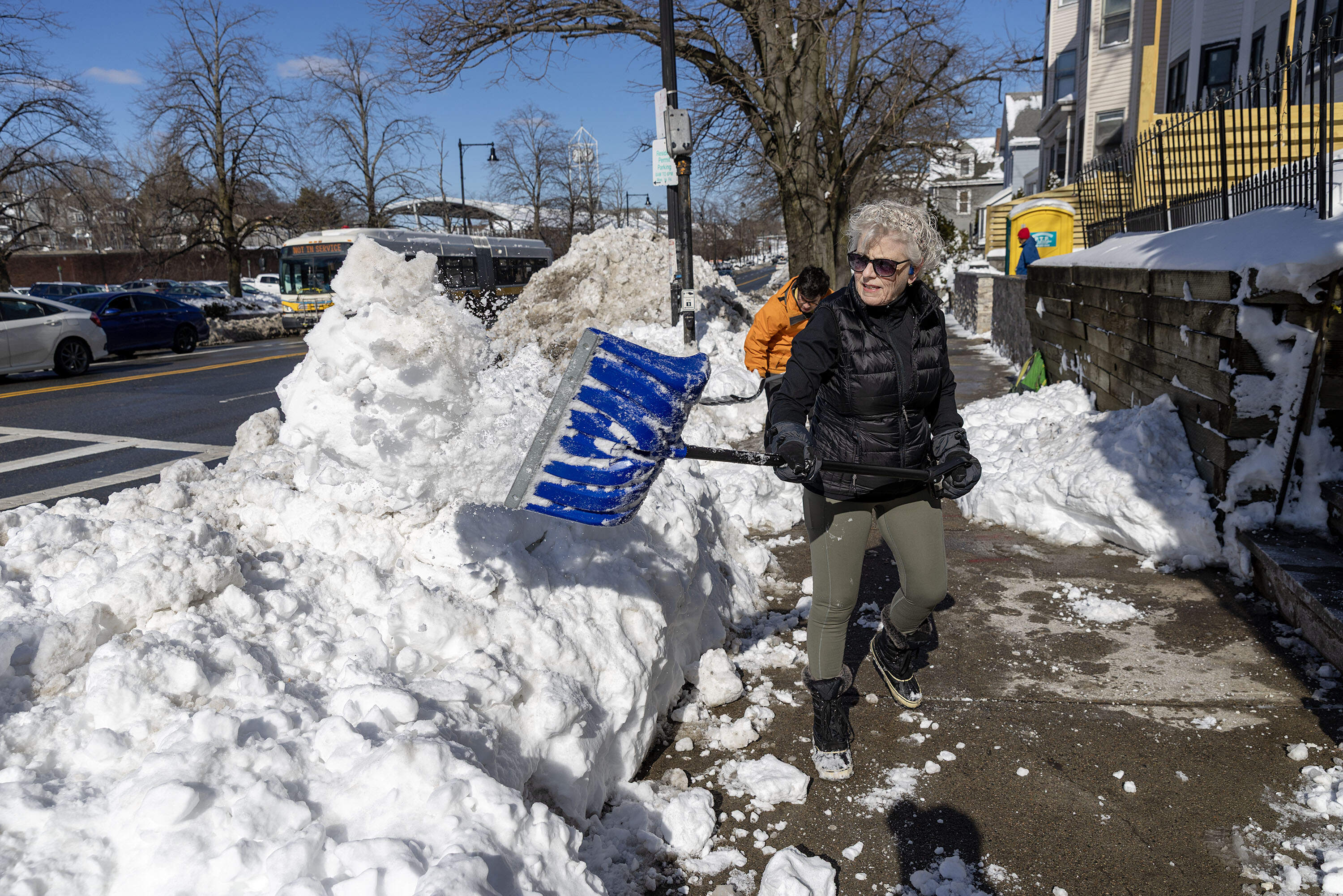Volunteer Meg O'Brien works with a crew the Boston Mayor's Office of Neighborhood Services brought together to clear crosswalks in Jamaica Plain. (Robin Lubbock/WBUR)