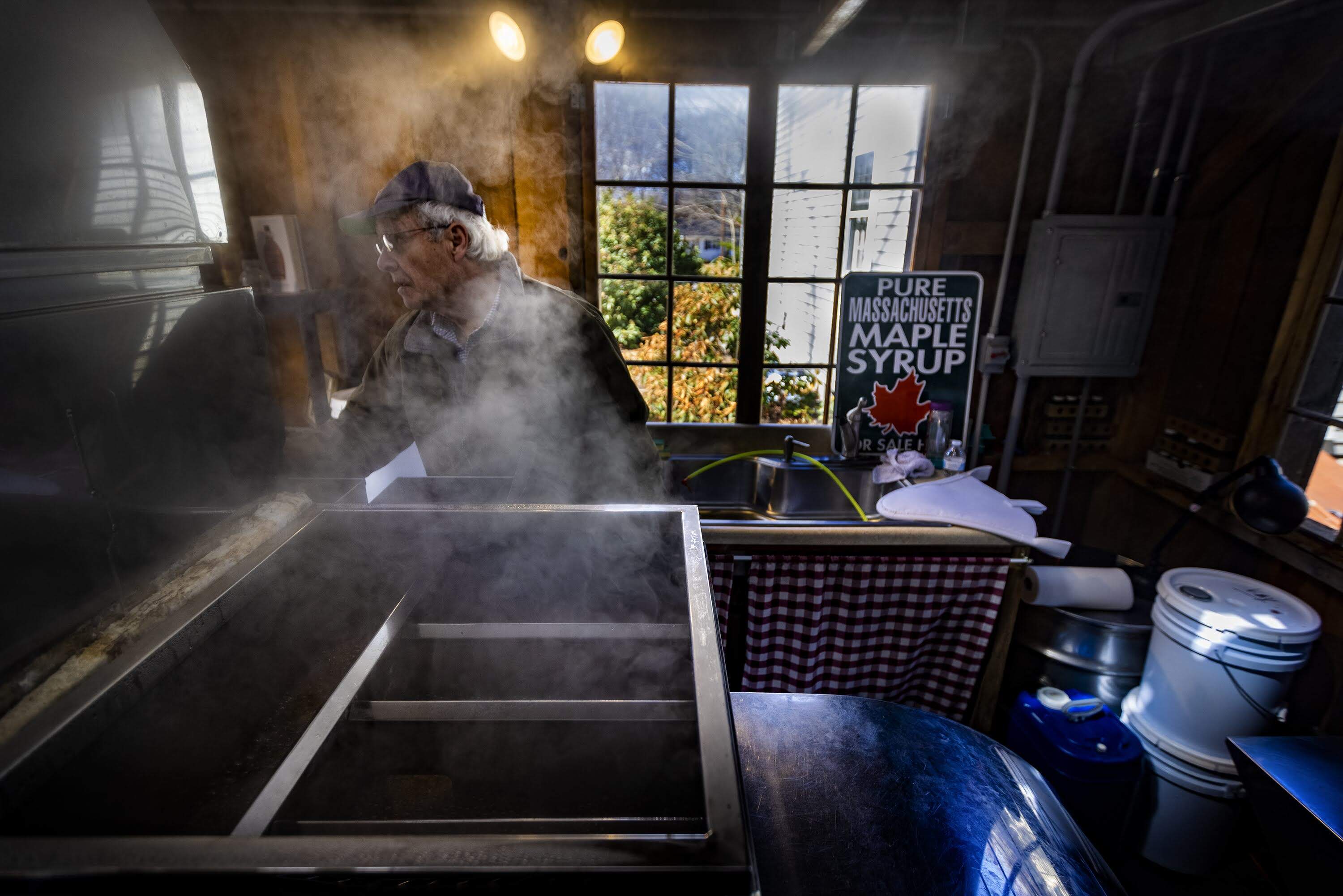 Ronald Kay checks the evaporator in the maple sugar shack at Maynard Maple to process maple sap he’s collected around the Maynard area to make locally sourced maple syrup. (Jesse Costa/WBUR)