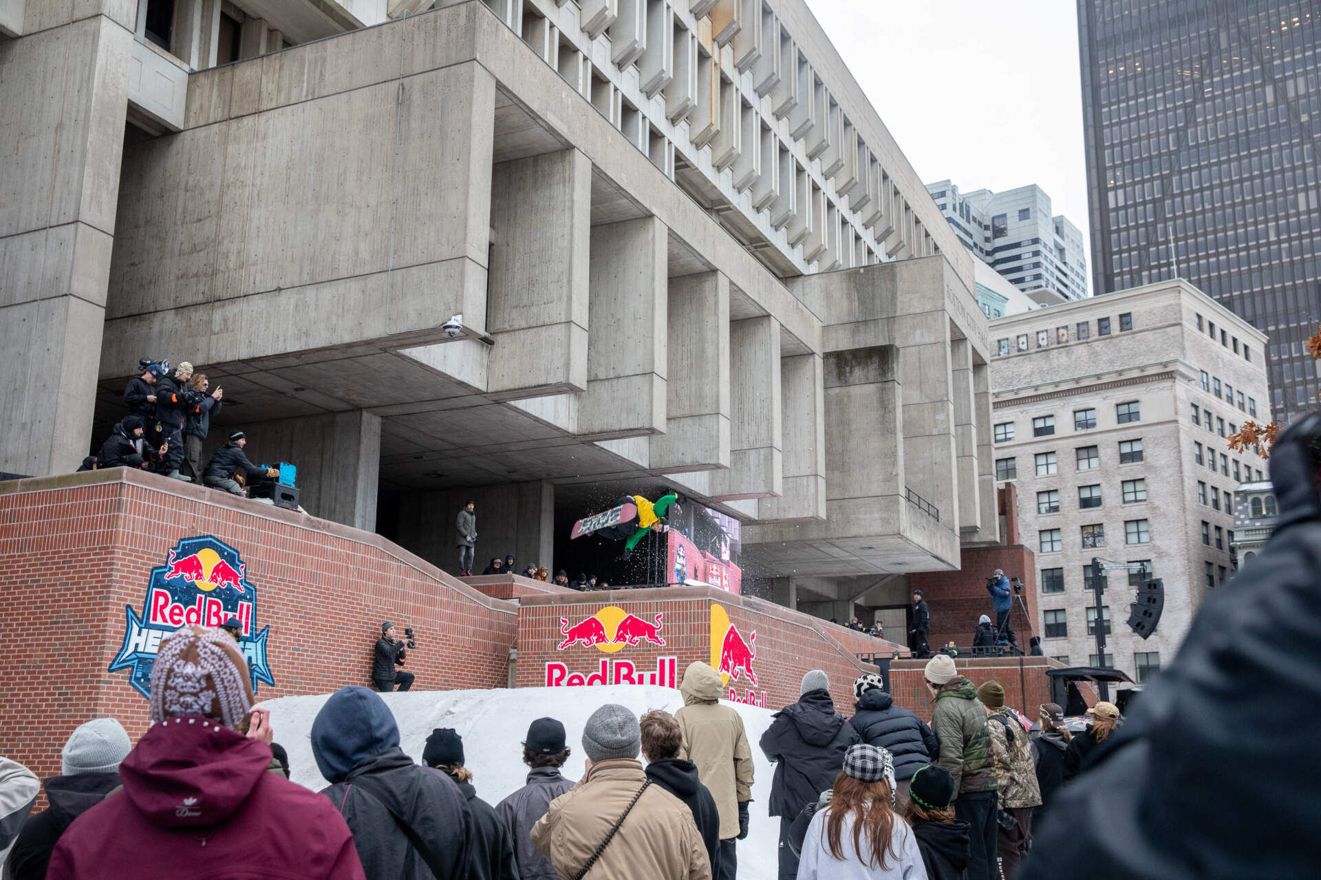 Snowboarder Irie Jefferson flies through the air in front of City Hall. (Artemisia Luk/WBUR)