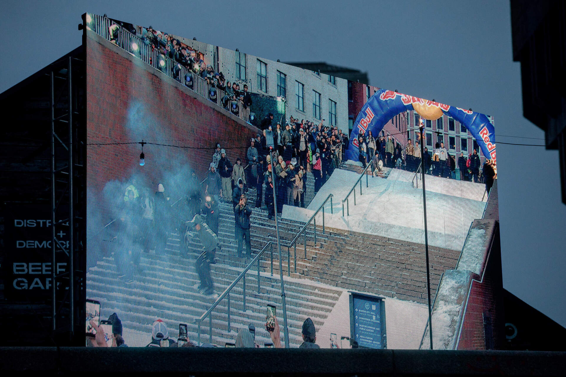 A jumbotron shows snowboarder Walker Netland gliding down a railing. (Artemisia Luk/WBUR)