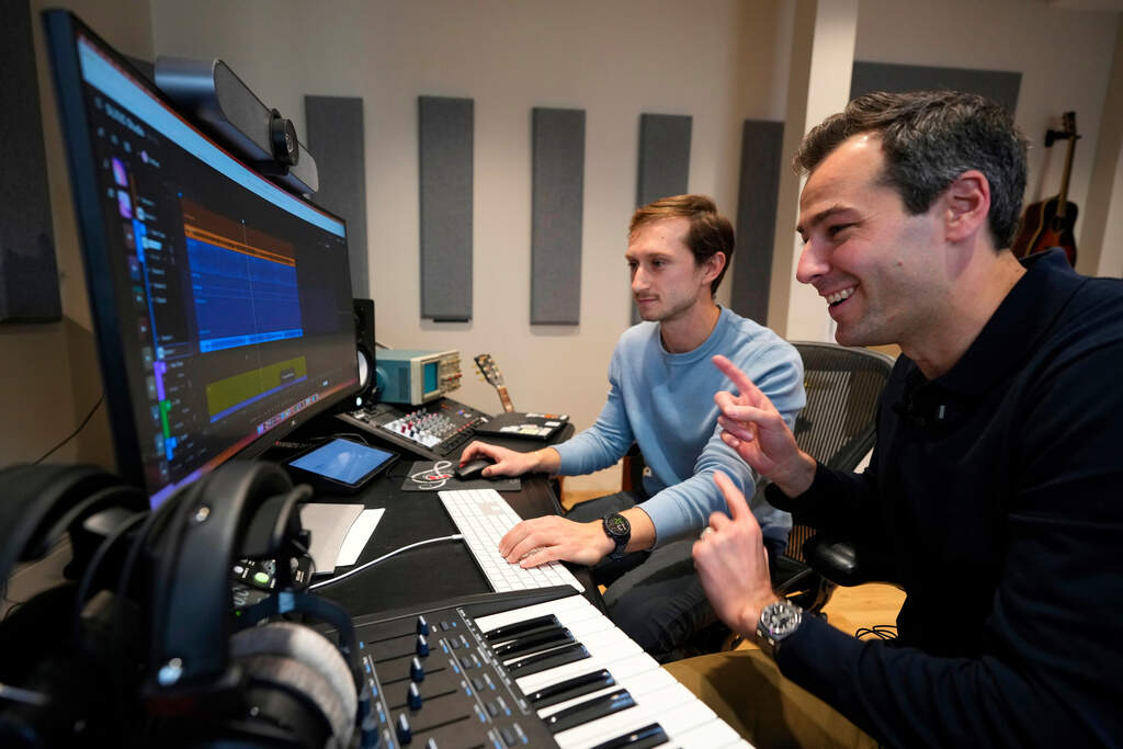 Mikey Shulman, one of the founders of AI music generator startup Suno, right, and research scientist Christian Steinmetz, collaborate on creating a song, Tuesday, Jan. 13, 2026, in Cambridge, Mass. (Robert F. Bukaty/AP)