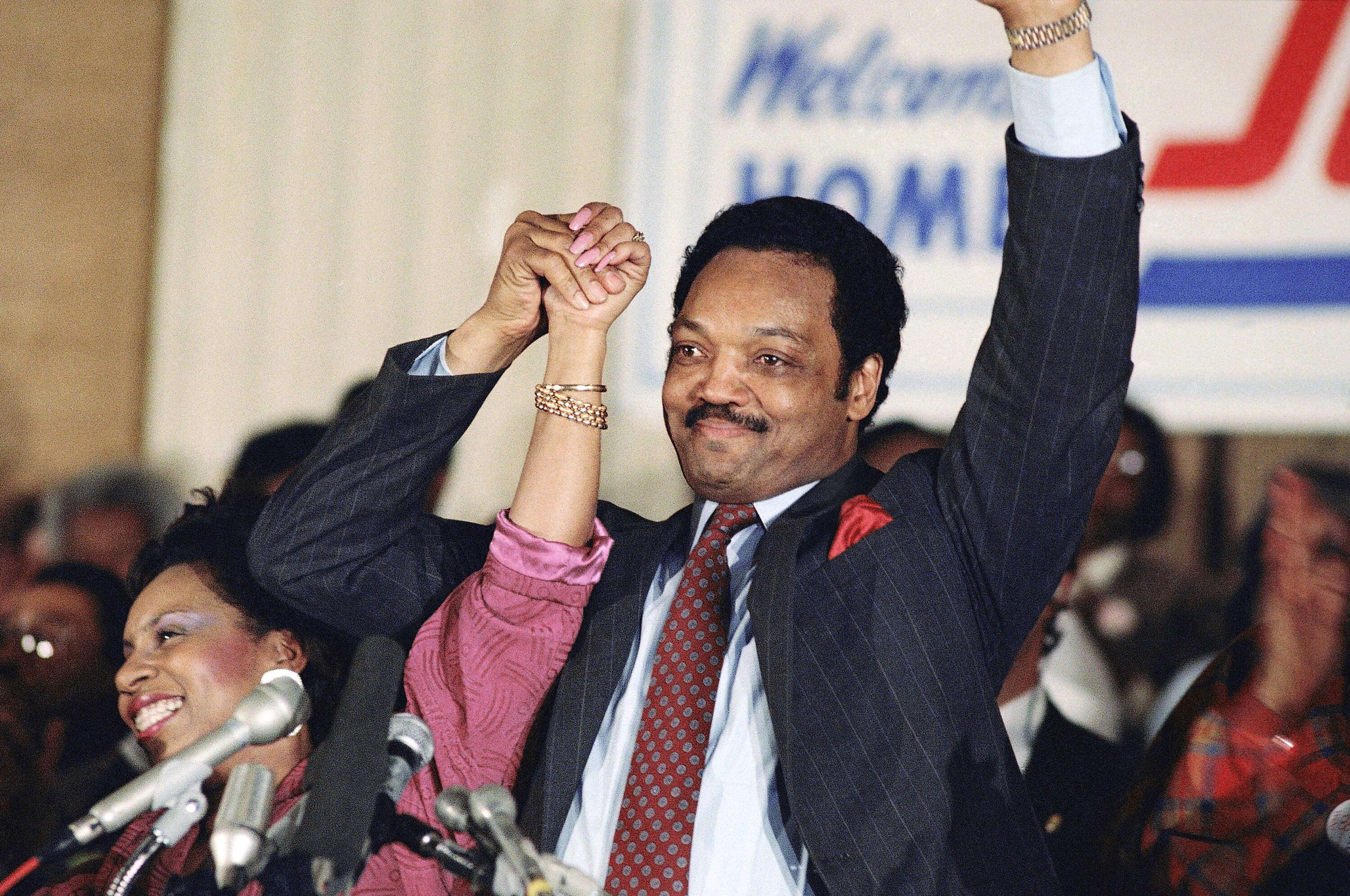 In this 1988 photo, Jesse Jackson with his wife, Jacqueline, salutes the cheering crowd at Operation Push in Chicago. (Fred Jewell/AP)