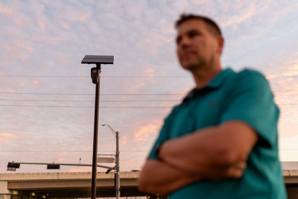 Alek Schott stands next to a Flock Safety license plate reader in his Houston neighborhood on Thursday, Oct. 16, 2025. (David Goldman/AP)