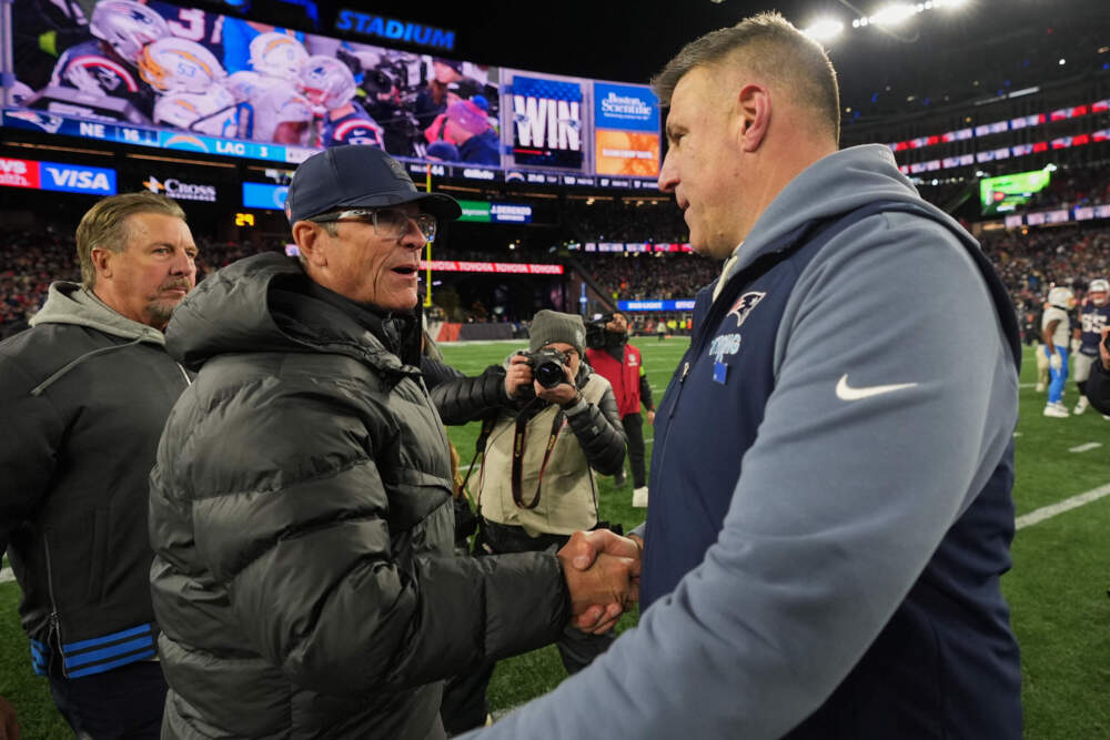 Los Angeles Chargers head coach Jim Harbaugh, left, and New England Patriots head coach Mike Vrabel, right, shake hands after their NFL wild-card playoff football game in Foxborough, Mass., Sunday, Jan. 11, 2026. (Charles Krupa/AP)