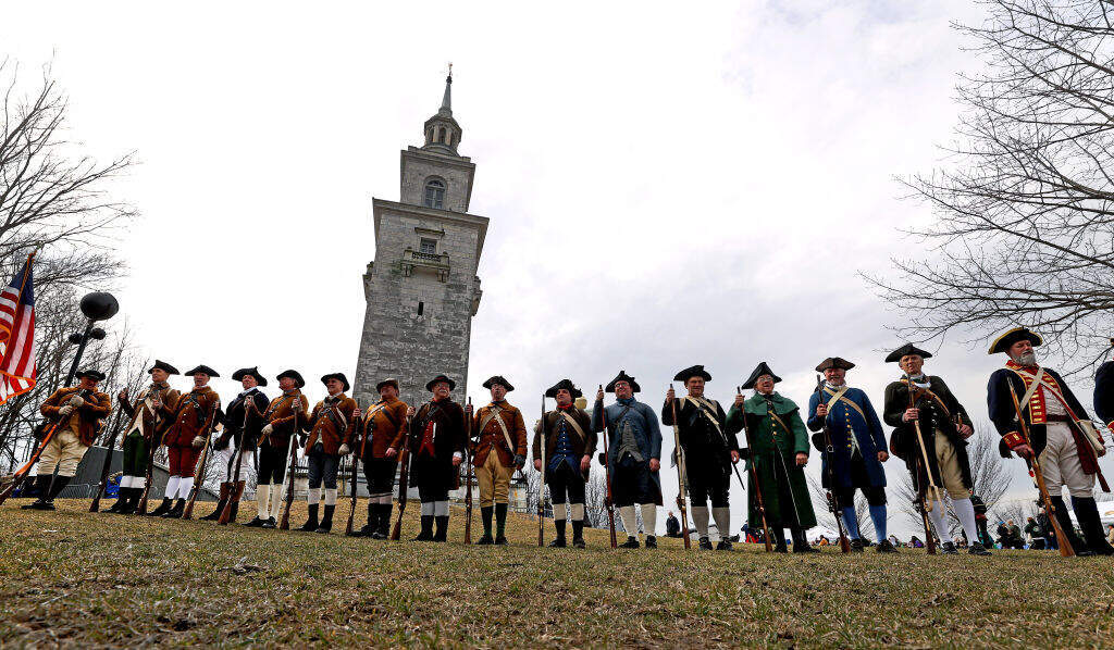 The Lexington Minutemen and a group of the Massachusetts Sons Of American Revolution stand atop of the hill in Boston during the annual commemoration of Evacuation Day in South Boston. (David L. Ryan/The Boston Globe via Getty Images)