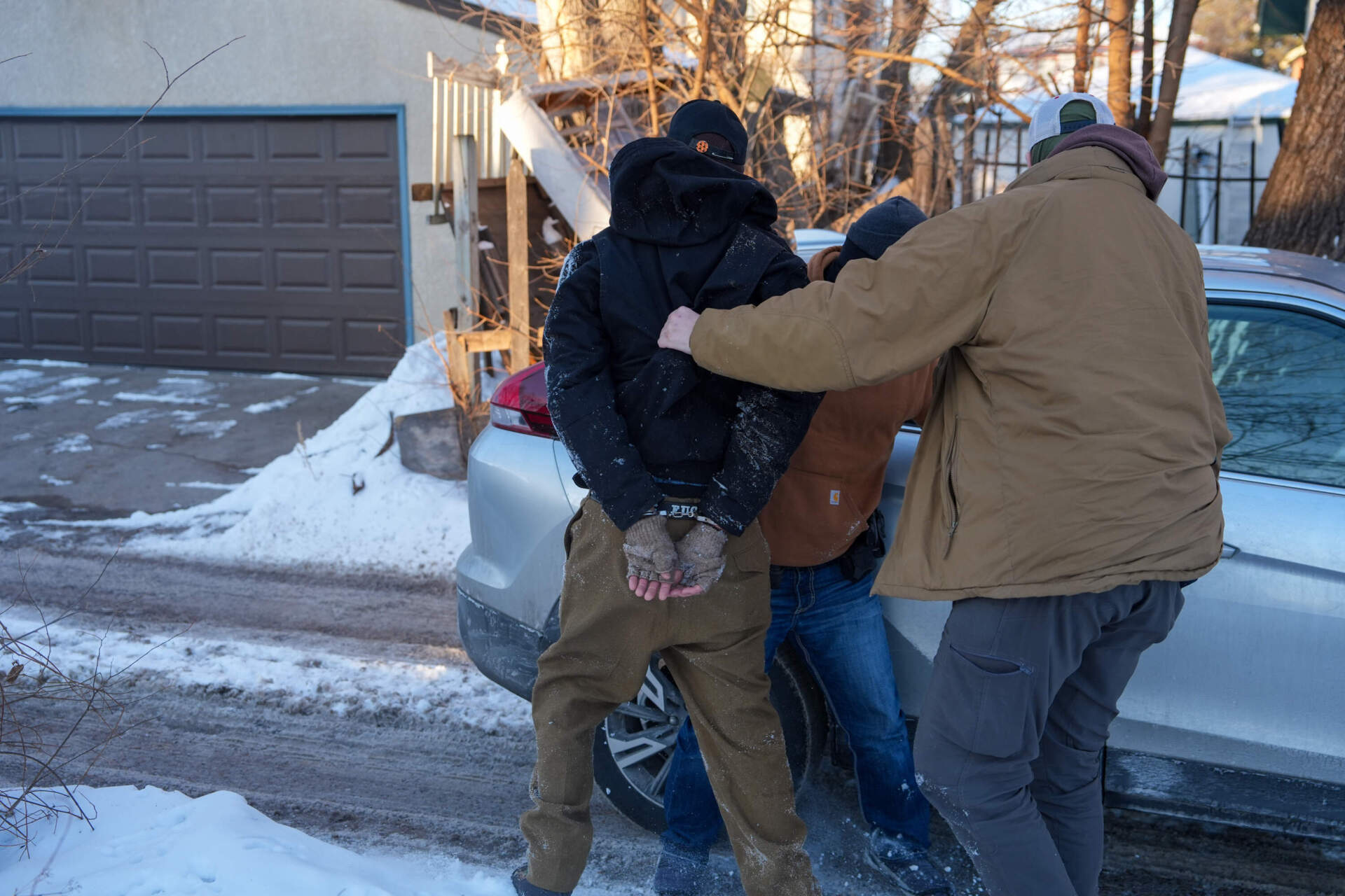 An activist is detained by federal agents on Tuesday, Feb. 3, in Minneapolis. (Ryan Murphy/AP)