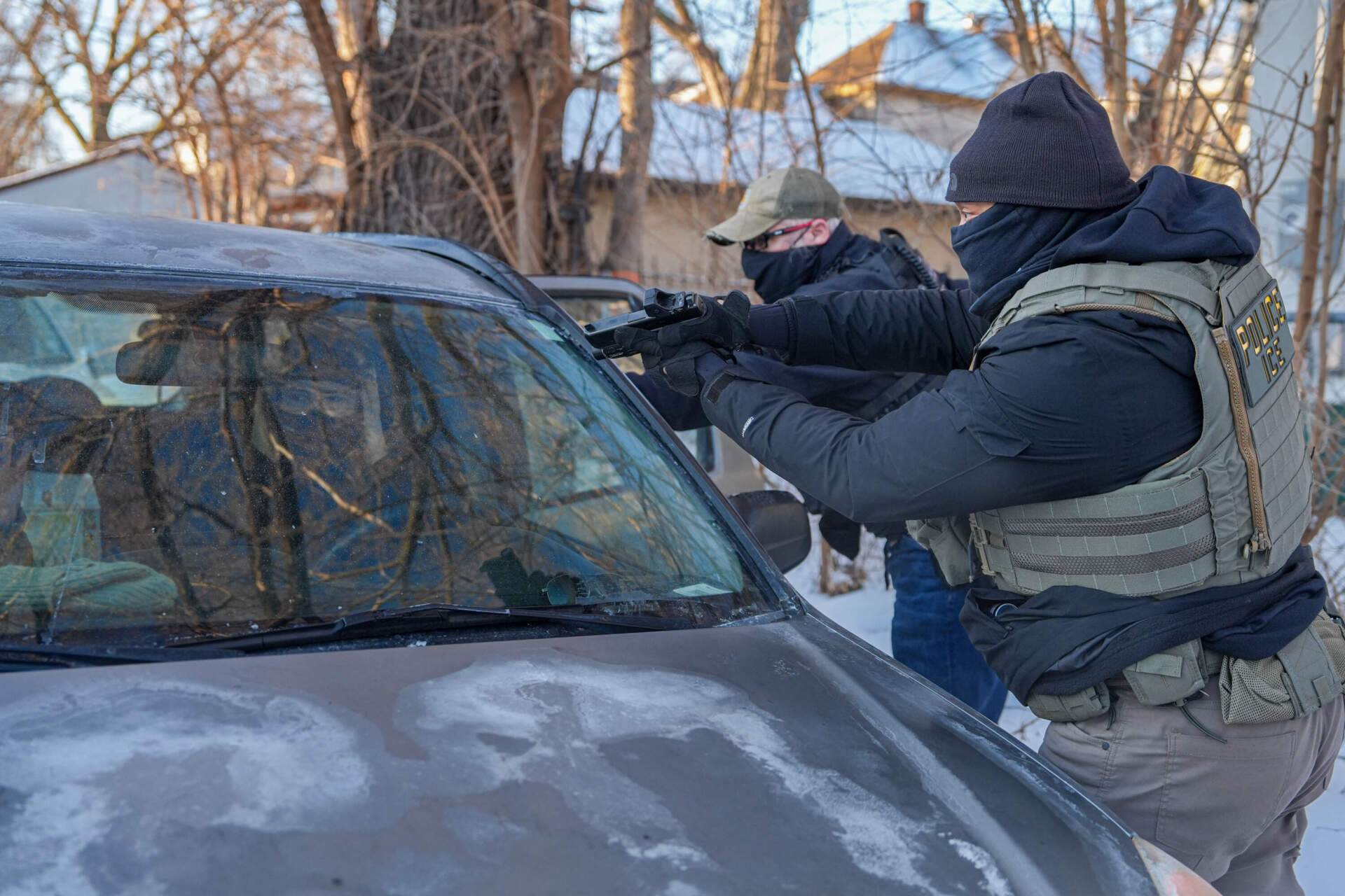 Activists are approached by a federal agent brandishing a firearm, after following agent vehicles on Tuesday, Feb. 3, in Minneapolis. (Ryan Murphy/AP)