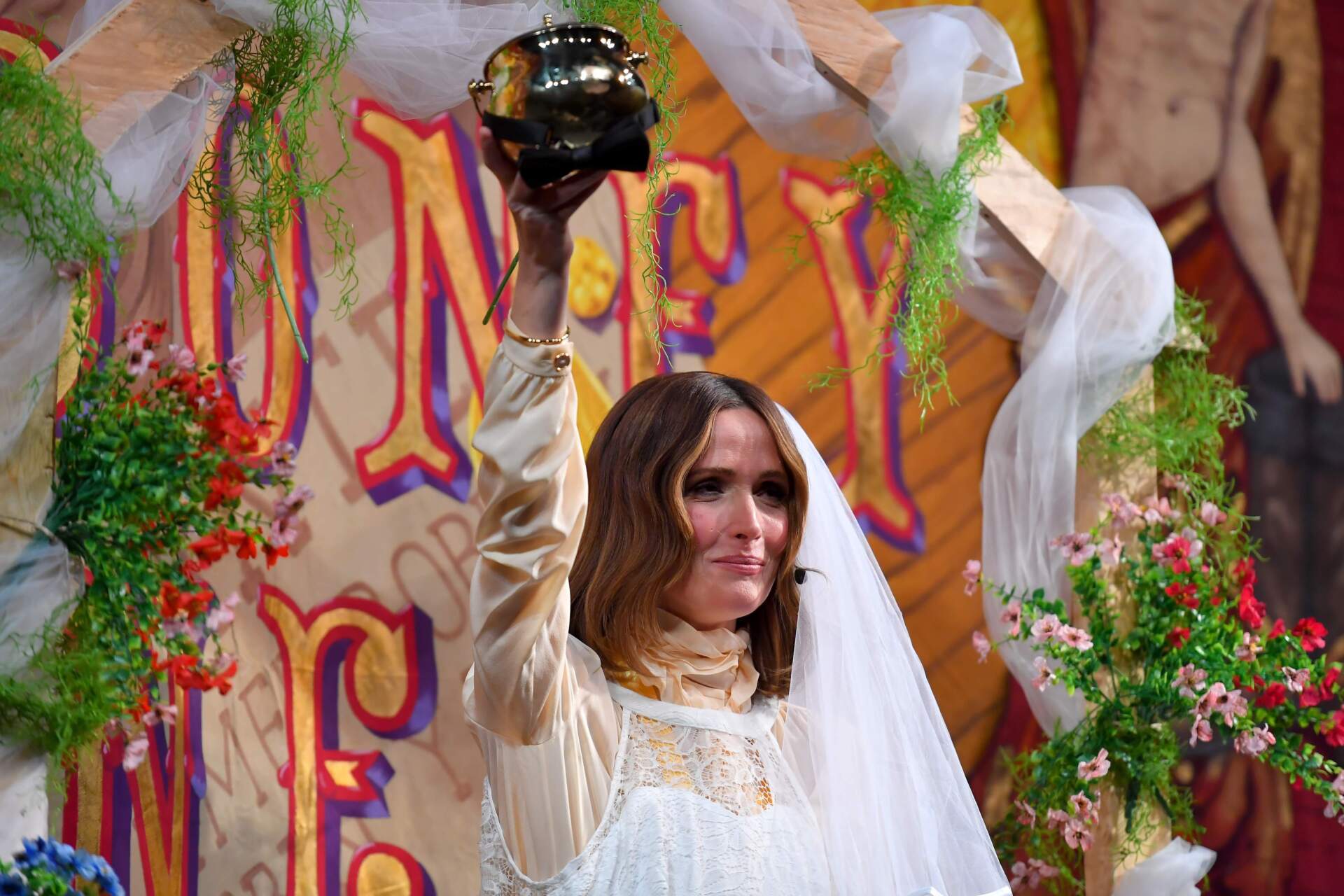 Rose Byrne, Hasty Pudding 2026 Woman of the Year, holds the Pudding Pot while wearing a wedding gown costume as she participates in a skit during a roast at Farkas Hall theater on Feb. 13 in Cambridge, Mass. (Steven Senne/AP)