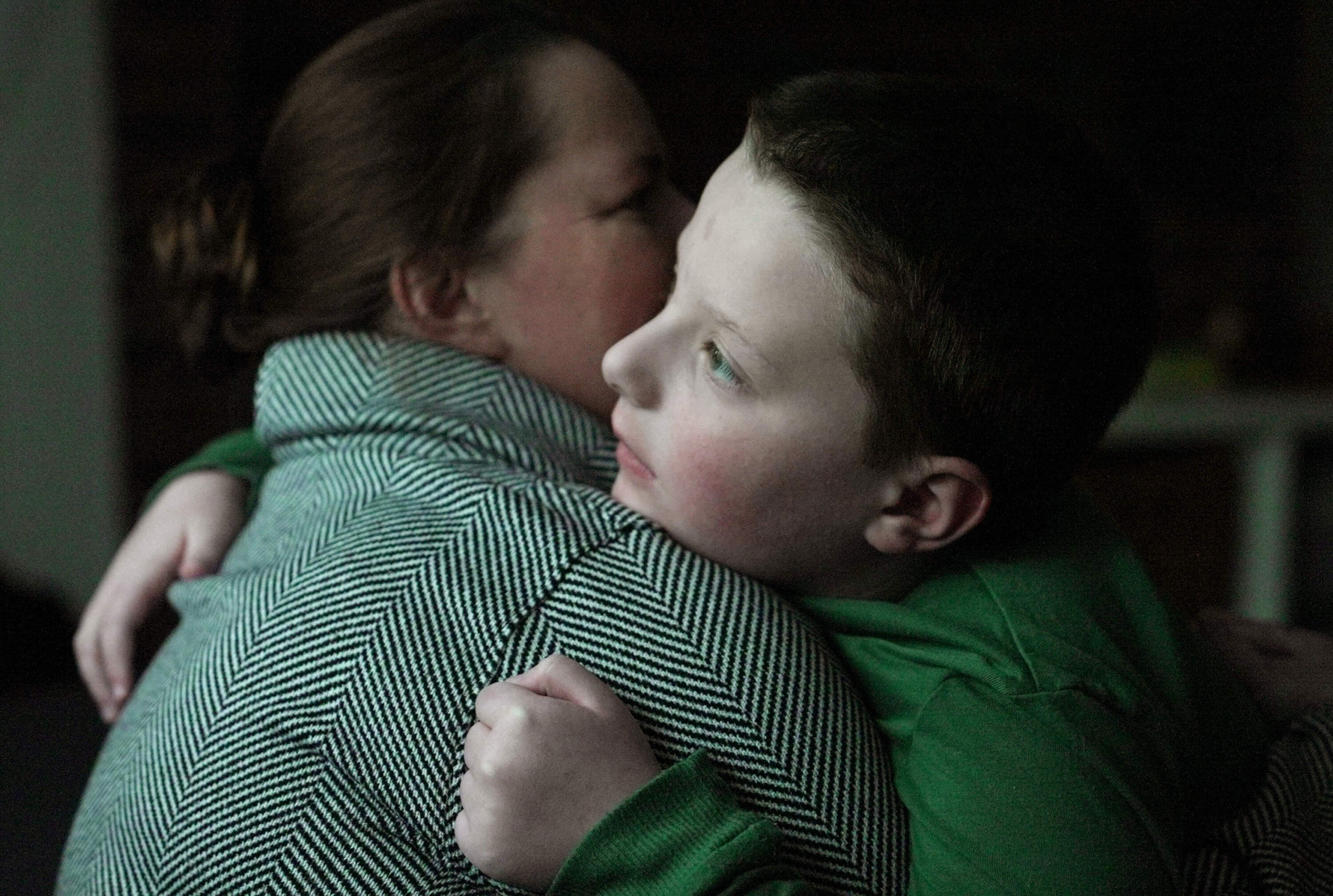Ronan Murphy hugs his mother, Andrea, while looking at the snow falling outside their home in Ayer, Mass., on Jan. 17. (Shelby Lum/AP)
