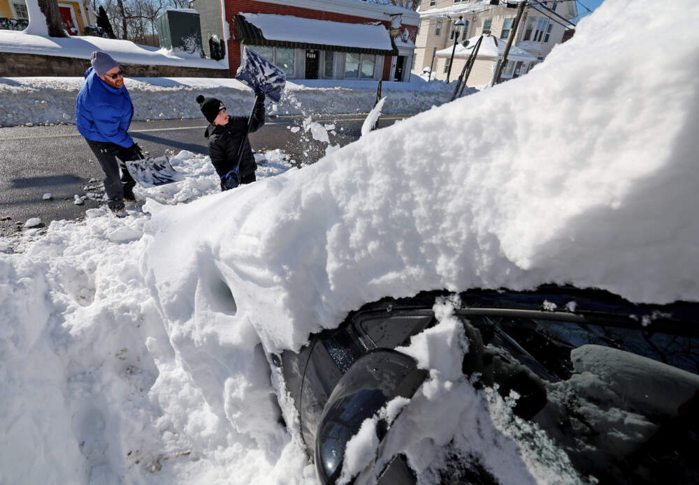 Larry Dolan, left, and his son Asher, 9, right, dig out their family car, Tuesday, Feb. 24, 2026, in Warwick, R.I. (Mark Stockwell/AP)