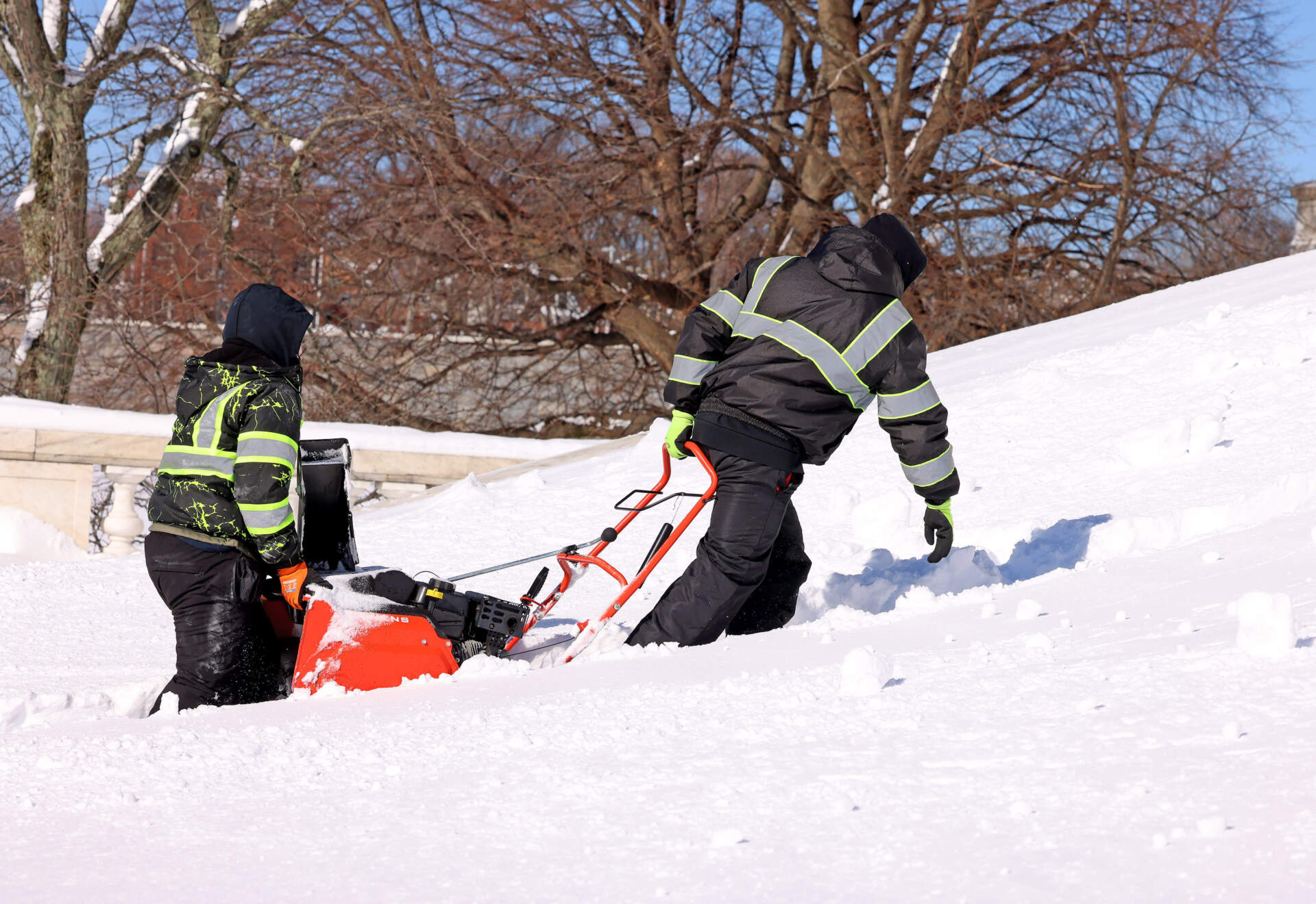 Two crew members carry a snowblower up the steps of the Rhode Island State Capital, Tuesday, Feb. 24, 2026, in Providence, R.I. (Mark Stockwell/AP)