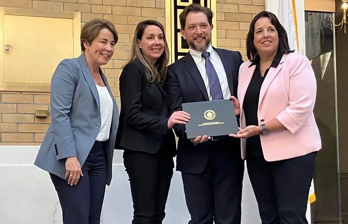 Gov. Maura Healey and Lt. Gov. Kim Driscoll pose for a photo with leaders from Boston Metal on Wednesday, June 26, 2024. (Alison Kuznitz/SHNS)