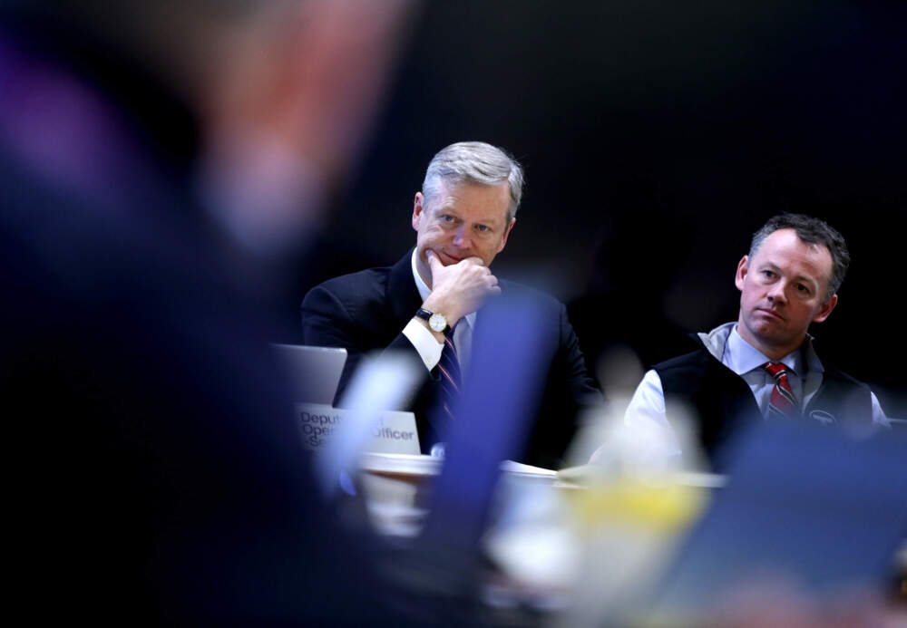 Then-Gov. Charlie Baker, left, and the MBTA's then-acting General Manager Brian Shortsleeve, right, met with other officials at the MBTA operations center to coordinate efforts for a weekend winter storm hitting the region in January 2017. (Jonathan Wiggs/The Boston Globe via Getty Images)