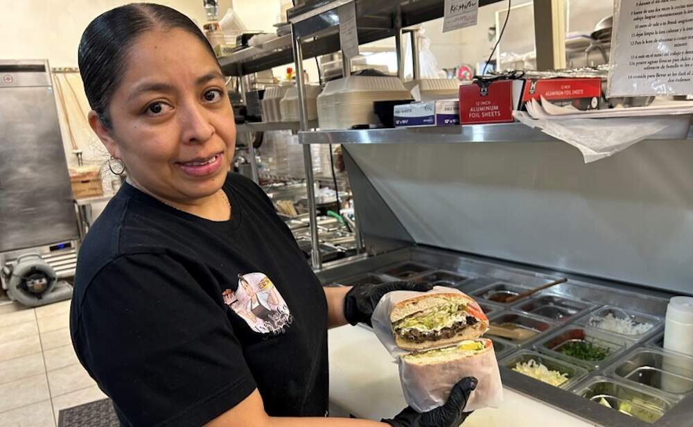 Flor Contreras, owner of Tres Leches Cake's Flor, prepares huaraches for customers. (Maine Public)