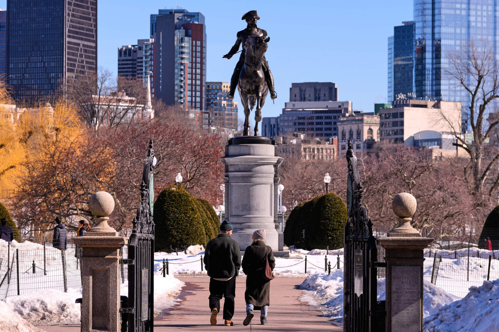 A couple walks toward a statue of George Washington on horseback at the Public Garden on Feb. 13 in Boston. (Charles Krupa/AP)