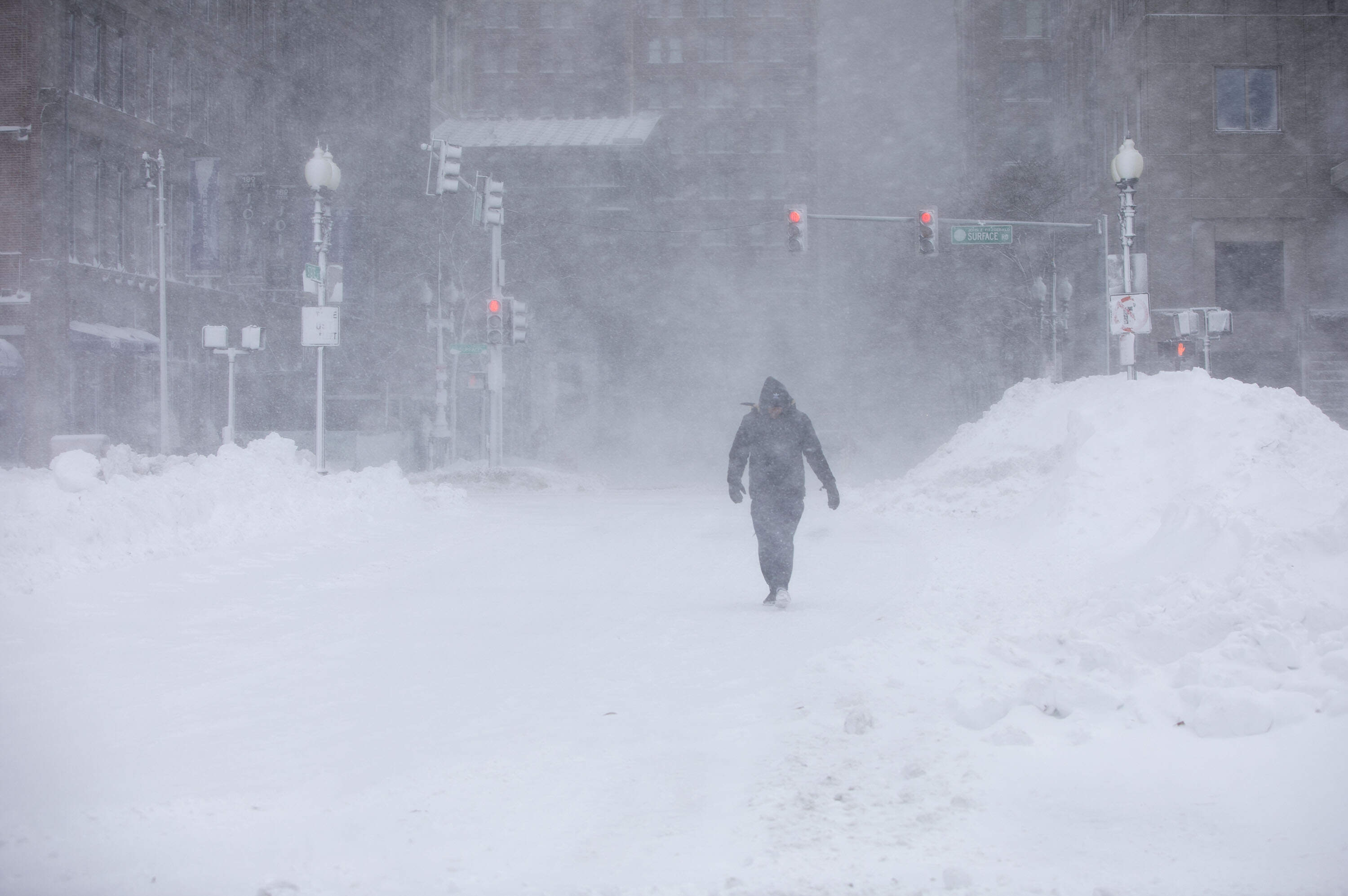 A pedestrian walks through wind and snow blowing along Atlantic Avenue in Boston, Feb. 23, 2026. (Robin Lubbock/WBUR)