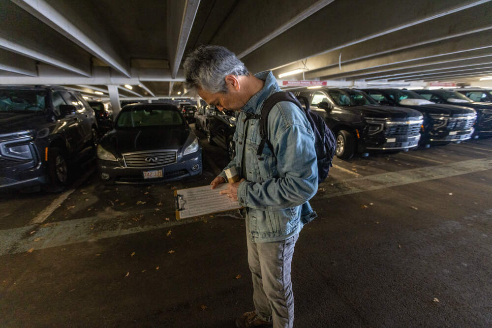Nathan Phillips surveys SUVs parked in the Burlington garage. (Jesse Costa/WBUR)