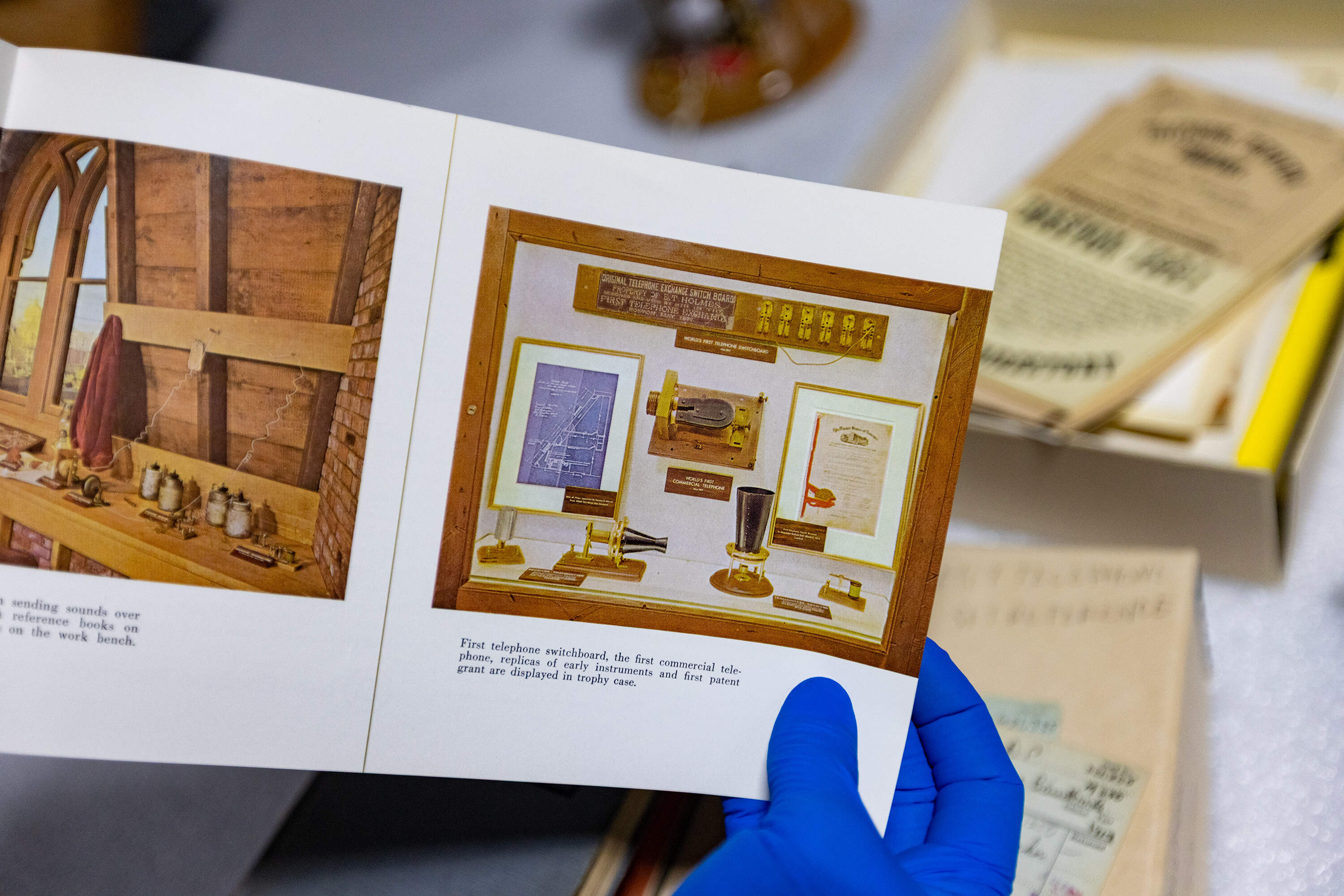 MIT Museum curator Florencia Pierri holds a vintage booklet which tells the history of the invention of the telephone published by Bell Telephone. (Jesse Costa/WBUR)