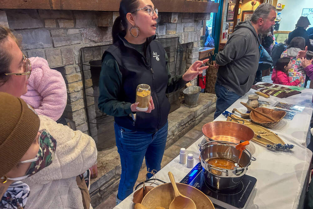 Leah Hopkins talks about maple sugaring for those gathered at the community event on Saturday. (Amanda Beland/WBUR)