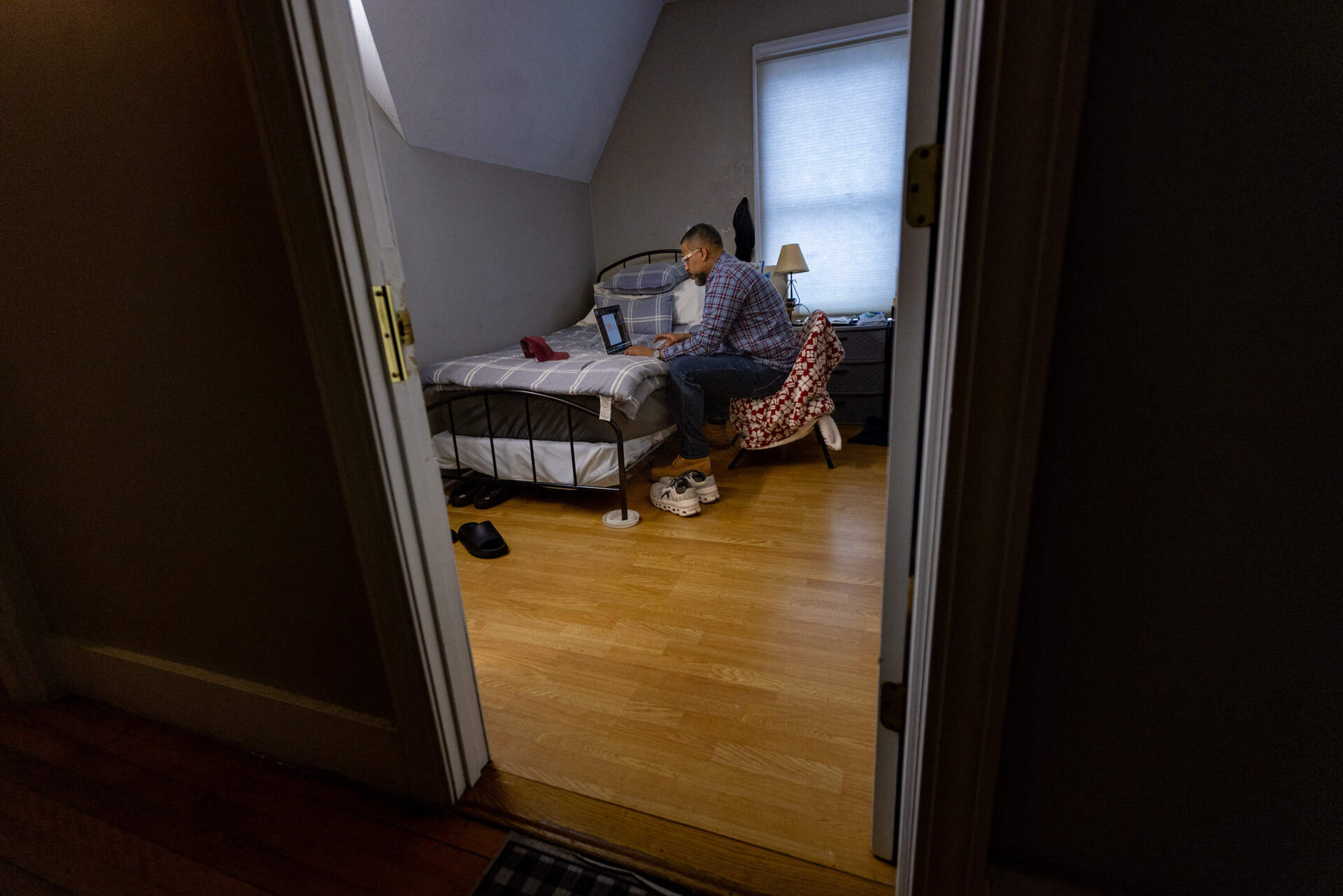 Robert Francis sits on his computer in his room at Dismas House using ChatGPT. (Jesse Costa/WBUR)