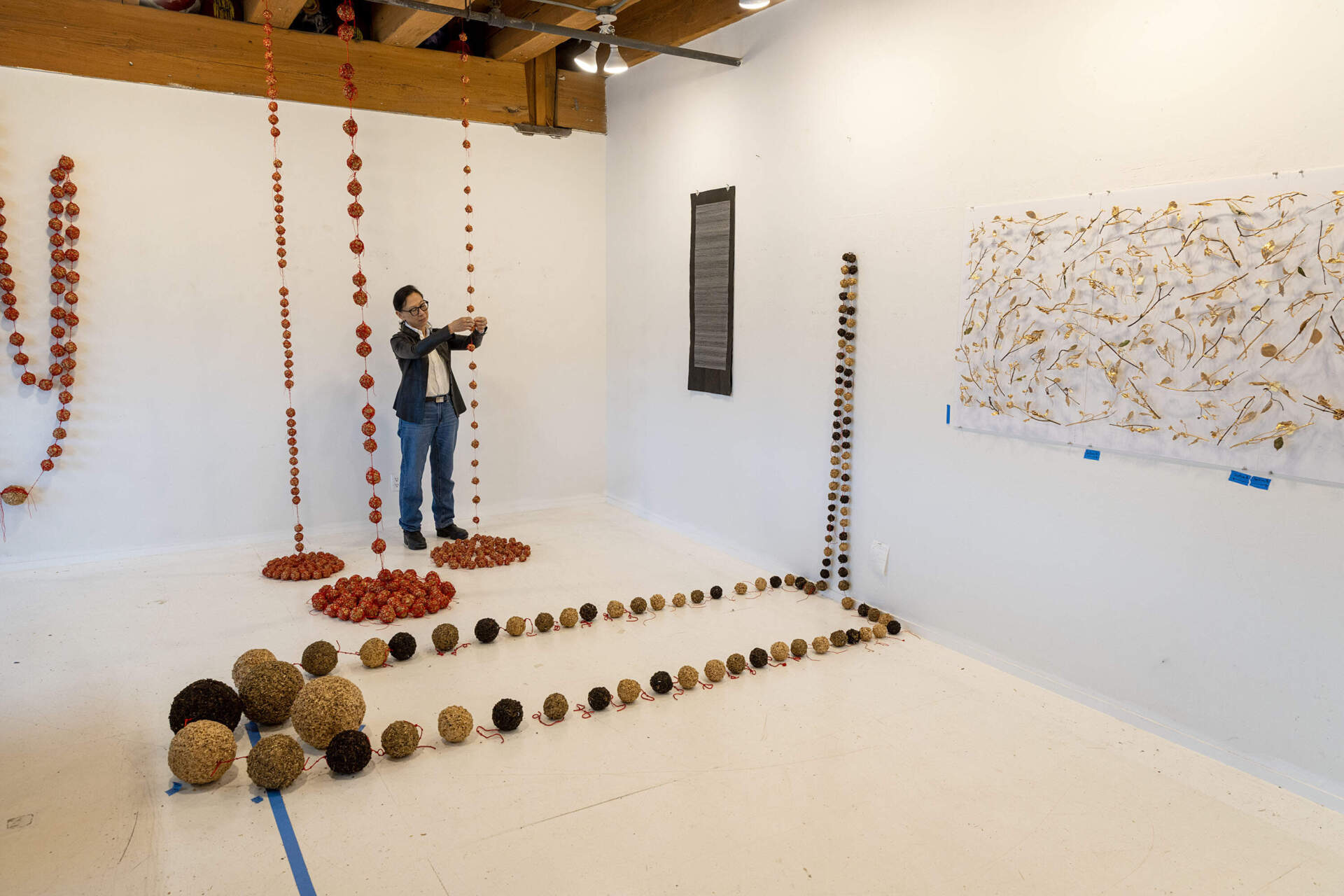 Artist Yu-Wen Wu looks over some of her work in progress at her studio in Boston. (Robin Lubbock/WBUR)