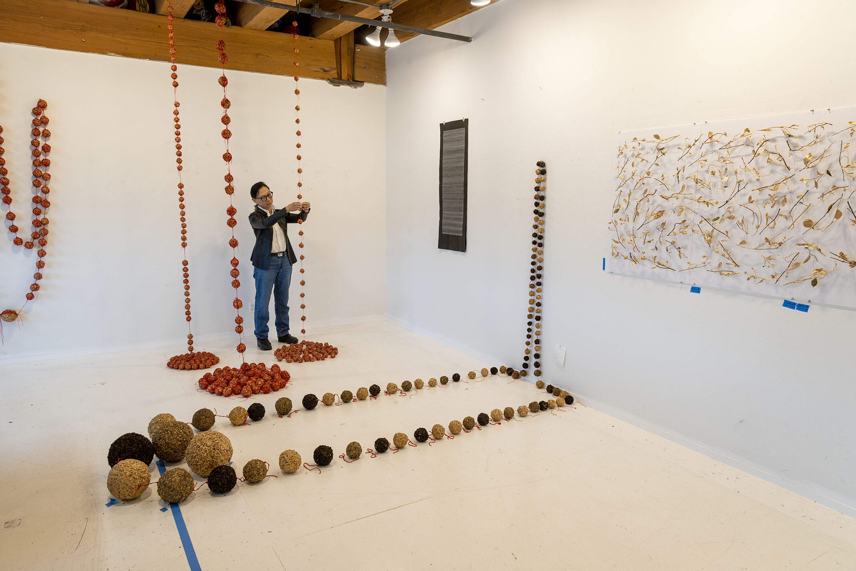 Artist Yu-Wen Wu looks over some of her work in progress at her studio in Boston. (Robin Lubbock/WBUR)