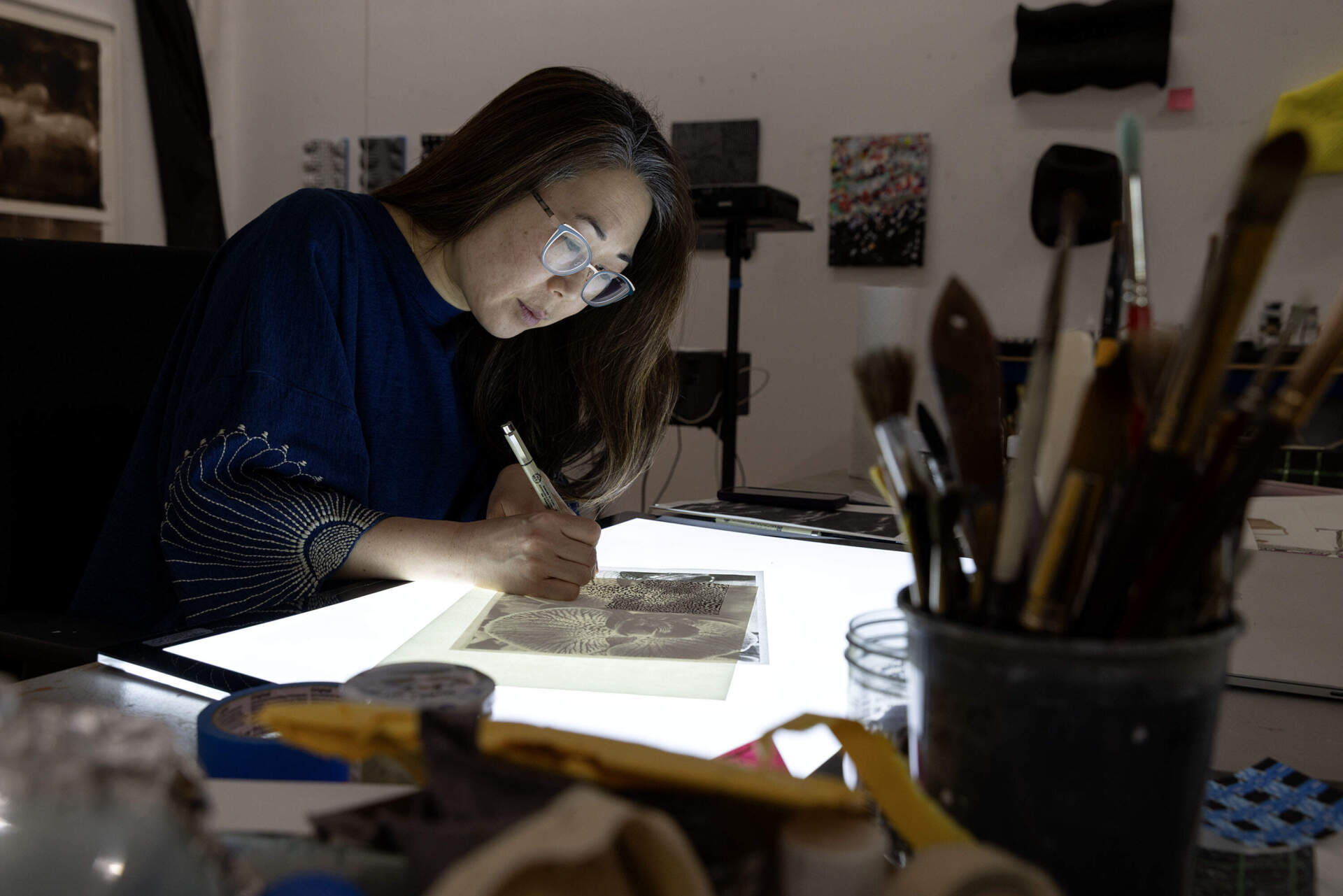 Artist Lucy Kim works on a tracing at her studio in Somerville. (Robin Lubbock/WBUR)