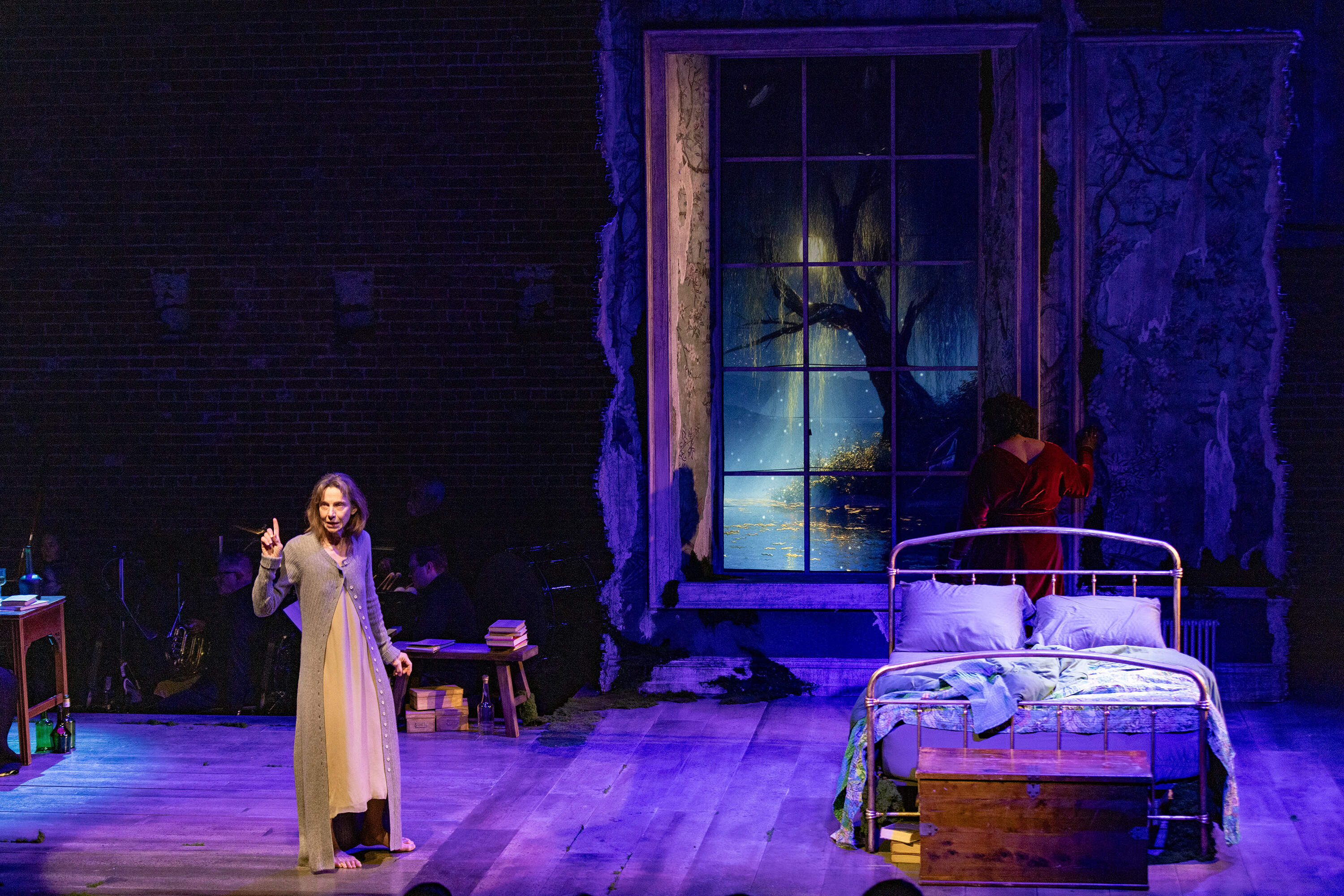 Ellen Lauren, as the Mother, performs on stage, as a maple tree appears in the large window, during the final rehearsal for the Boston Lyric Opera production of “The Song of the Earth.” The projection was made possible by the lighting wizardry of Masary Studios. (Jesse Costa/WBUR)