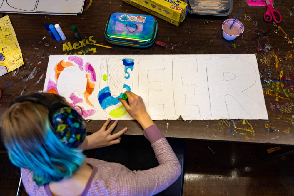 Eighth grader Adelaide Csinsi designs one of the dozens of signs that hang around Boston Green Academy. (Jesse Costa/WBUR)