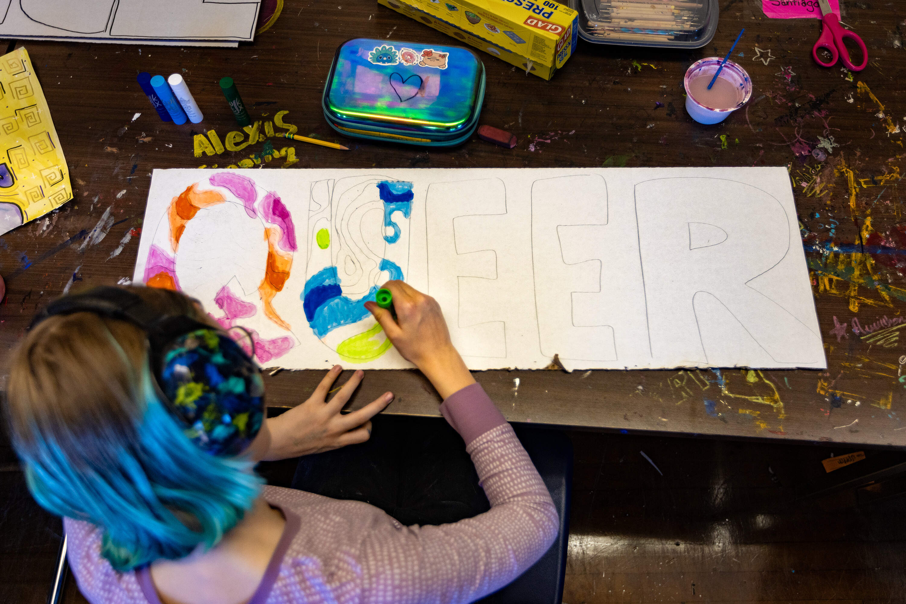 Eighth grader Adelaide Csinsi designs one of the dozens of signs that hang around Boston Green Academy. (Jesse Costa/WBUR)