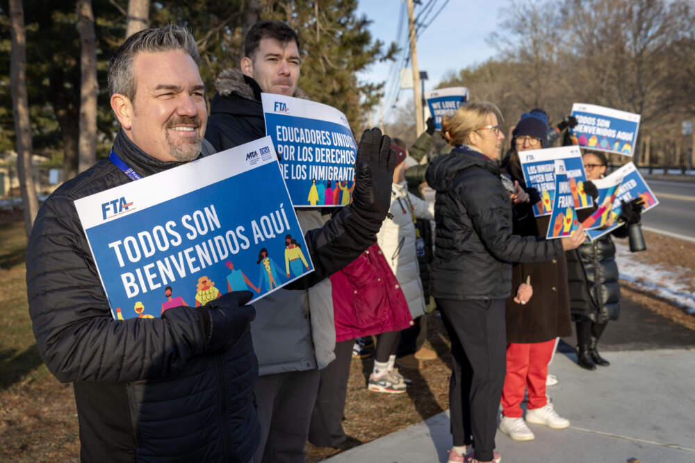 Framingham Public Schools Superintendent Bob Tremblay (left) joins teachers at a "stand out" to support immigrants and welcome students as they arrive at Barbieri Elementary School. (Robin Lubbock/WBUR)