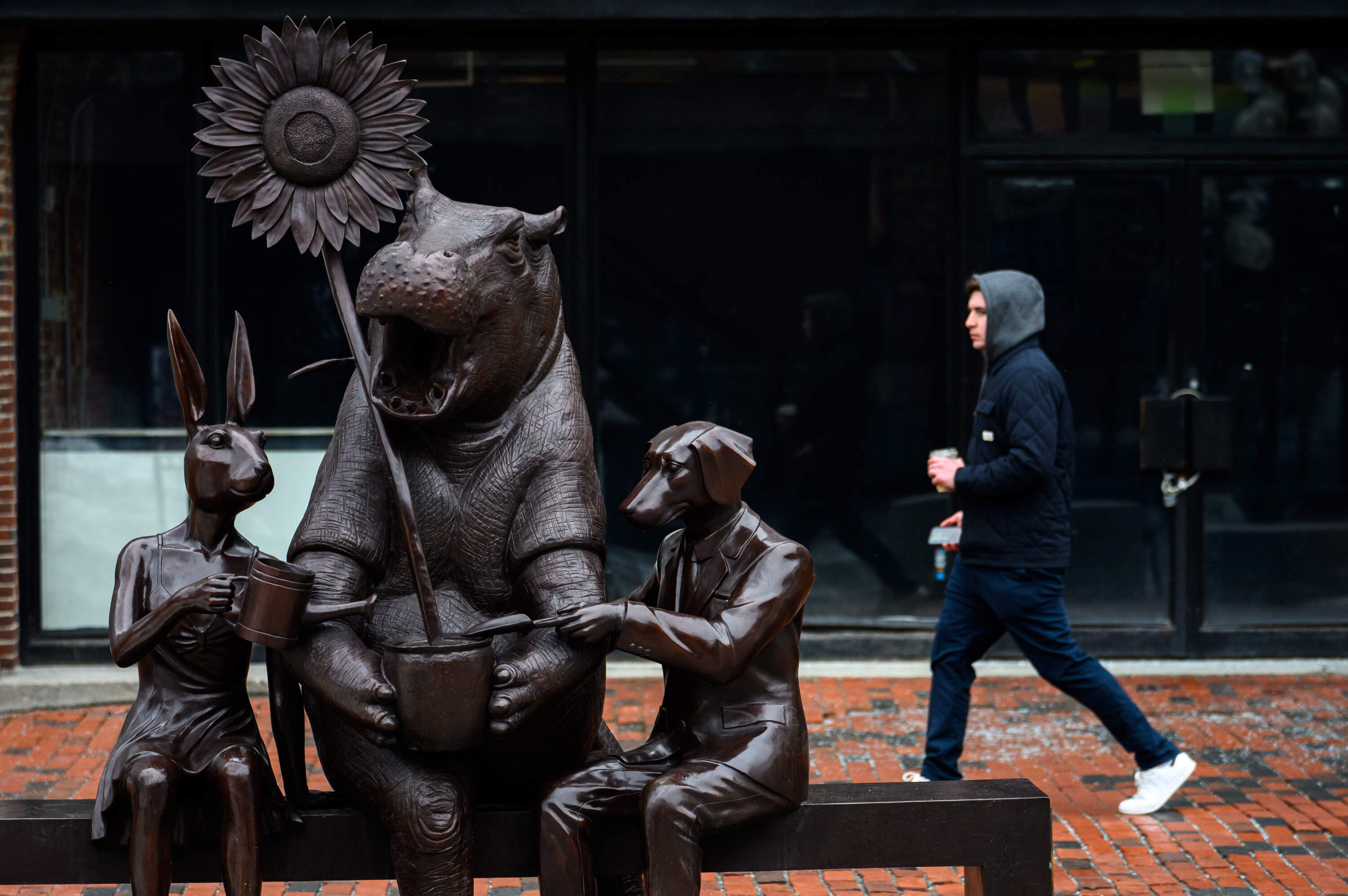 A passerby walks past the installation, which also includes a hippo. (Andrew Burke-Stevenson for WBUR)