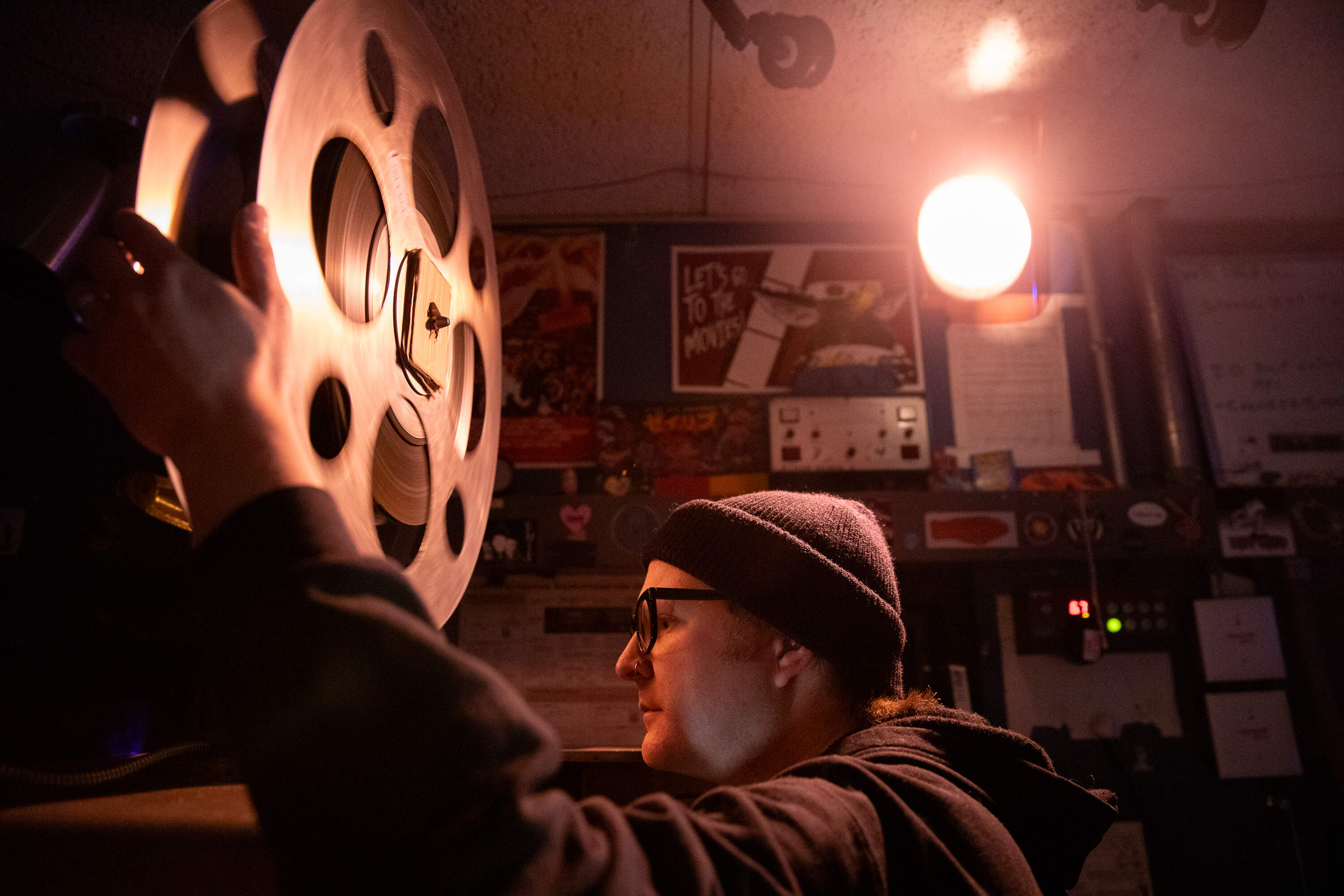 Tom Welch, lead projectionist at the Coolidge Corner Theater, loads a reel of film onto one of the projectors. (Artemisia Luk/WBUR)