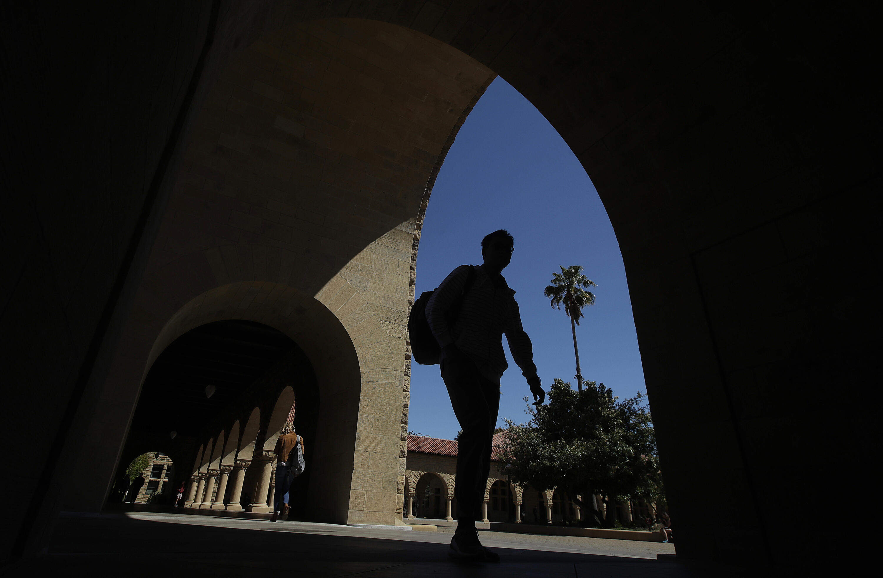 In this April 9, 2019, file photo, pedestrians walk on the campus at Stanford University in Stanford, Calif. (Jeff Chiu, AP)