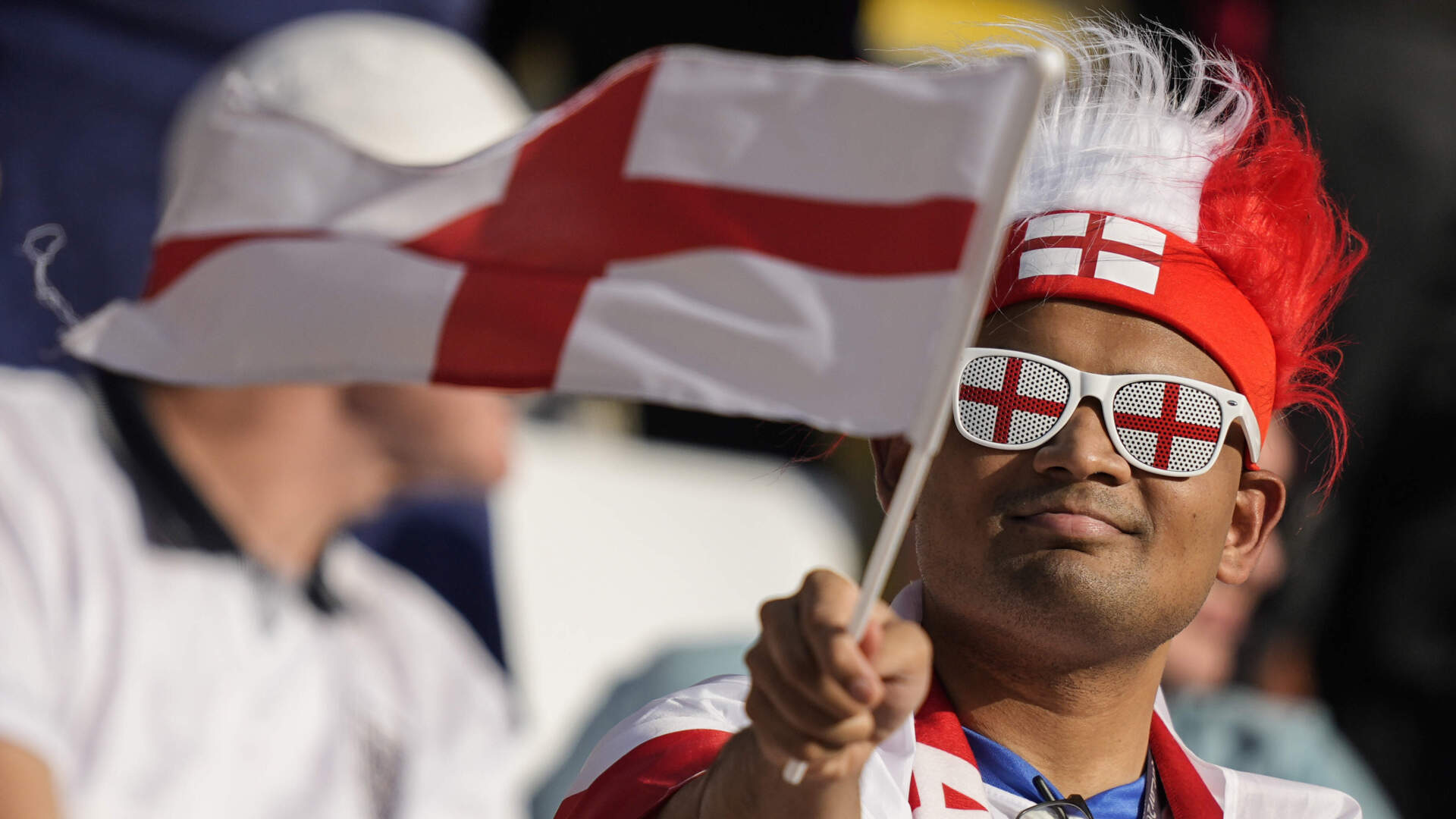 A fan of the English team waves the flag of England before the start of a 2022 World Cup match against Iran. (Martin Meissner/AP)