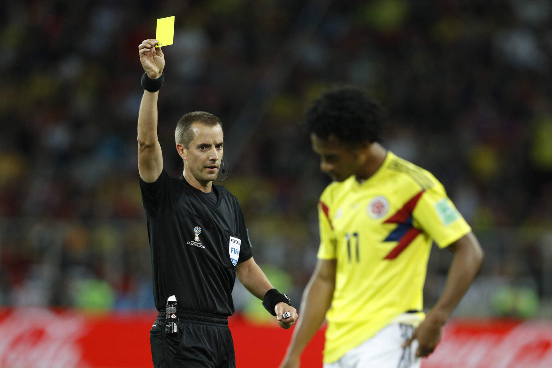 Referee Mark Geiger shows a yellow card to Colombia's Juan Cuadrado during the 2018 soccer World Cup. (Victor R. Caivano/AP)