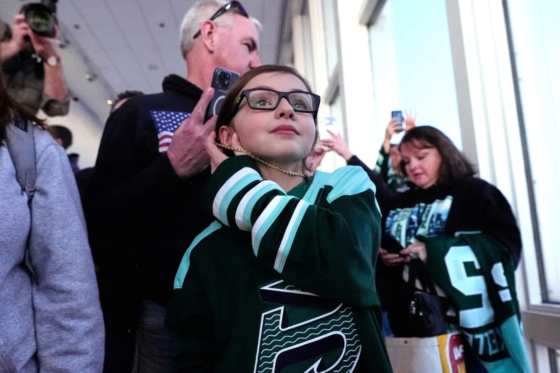 Mackenzie Binns, center, who drove with her parents five hours from their home in Syracuse, is first in line to meet players from the United States women's gold medal hockey team during a gathering with fans, Monday, March 2, 2026, in Boston. (Charles Krupa/AP)
