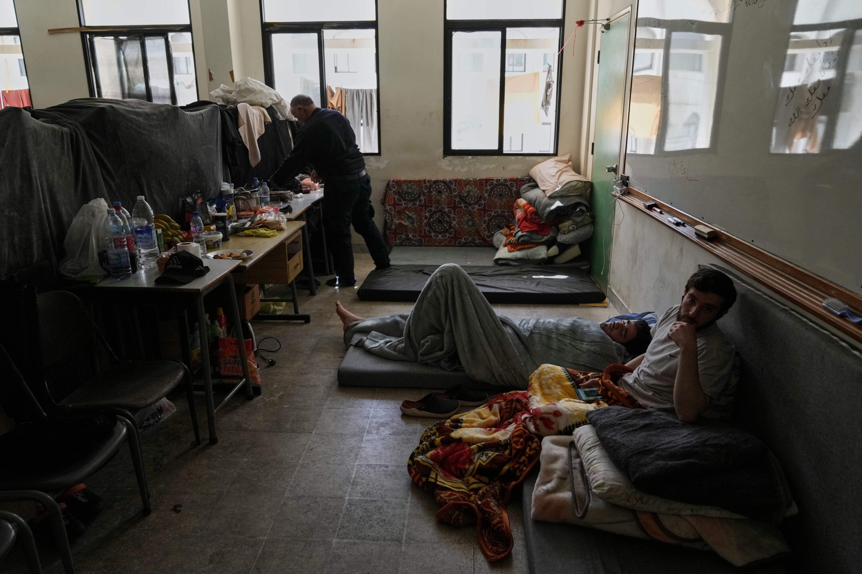 Displaced people fleeing Israeli airstrikes in southern Lebanon settle at the Bir Hassan Technical Institute, which has been turned into a shelter, in Beirut, Lebanon, Wednesday, March 11, 2026. (Bilal Hussein/AP)