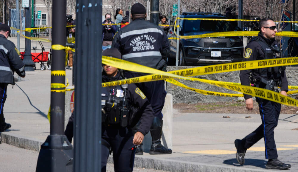 Law enforcement officials work a crime scene at Forest Hills train station. (Charles Krupa/AP)