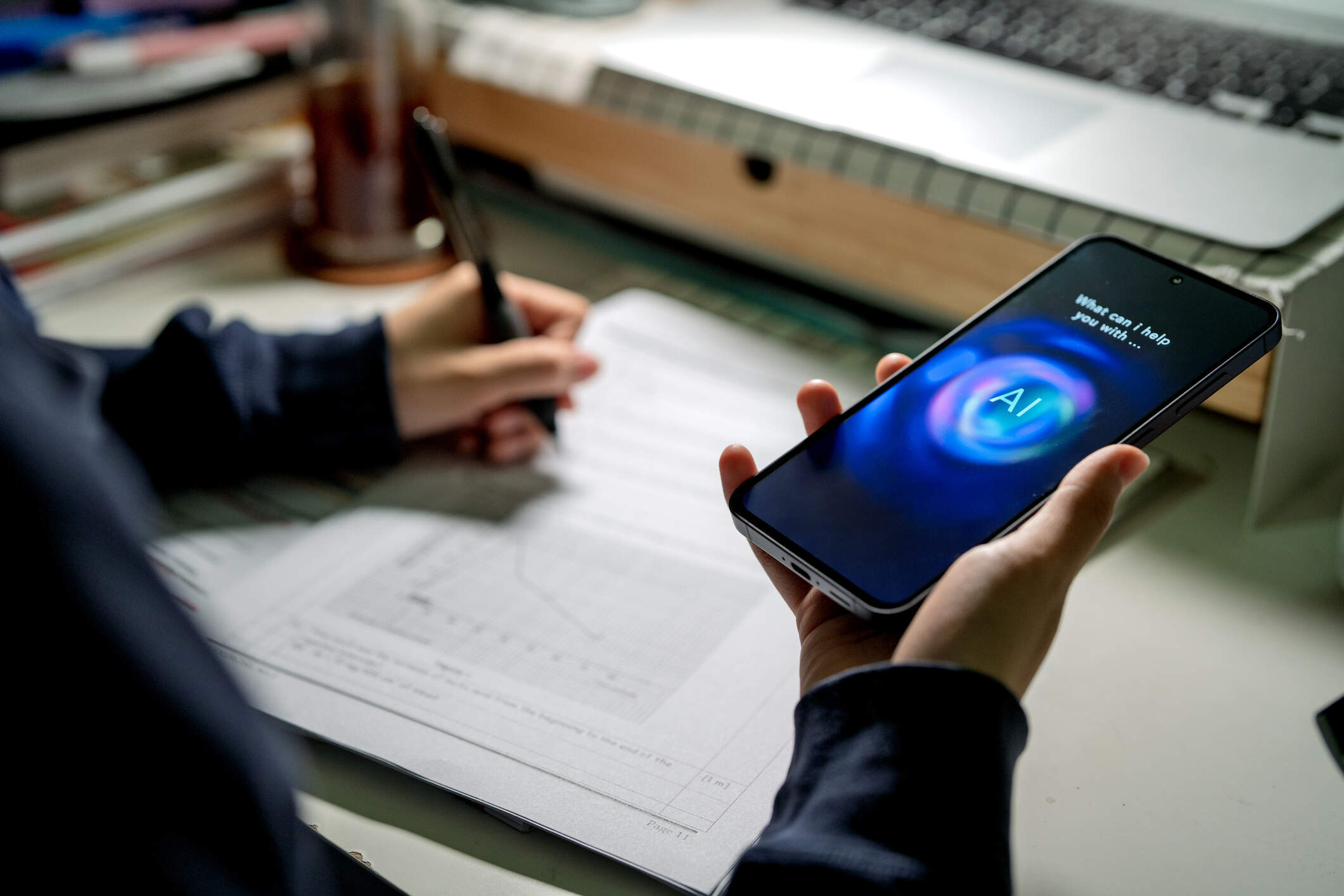 A student uses artificial intelligence on a phone while completing a school assignment. (Business Wire/AP)