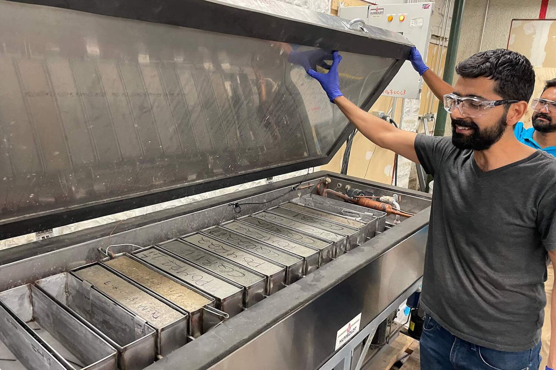 Mehdi Rashidi, senior research scientist at Sublime Systems, conducts a durability test on blocks of concrete in a freeze-thaw chamber. (Daniel Ackerman/WBUR)