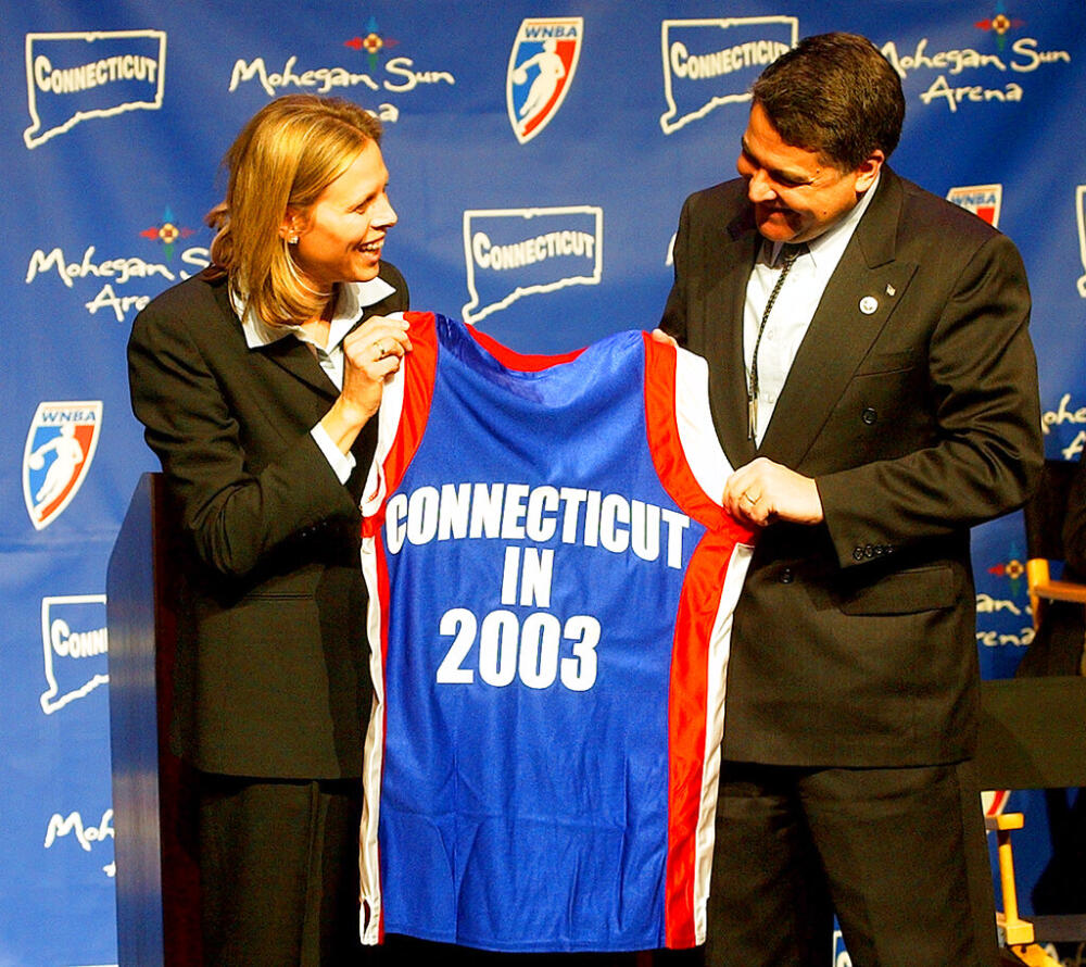 WNBA League President Val Ackerman, left, and Mohegan Tribe Tribal Chairman Mark Brown hold a basketball shirt of the type that will be worn by the WNBA team Connecticut Sun during a news conference Tuesday, Jan. 28, 2003, at the Mohegan Sun Arena in Uncasville, Conn. (Bob Child/AP, File)